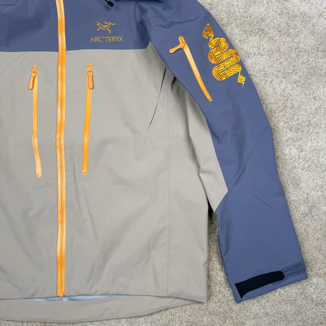 图片[7]-＃TZD Arcteryx Alpha SV 7 GORE-TEX Pro 始祖鸟第七代刺绣Logo图案休闲运动连帽拉链硬壳户外远足防水冲锋衣 蛇年限定 台州顶级批次 现货供应众所周日每年始祖鸟都会以十二生肖为思路出一款联名款的新年限定，今年也不例外此次的蛇年限定胸口logo为金标衣袖上的蛇形图案也很吸睛帽子上还有蛇鳞为点缀整个衣服的颜色为金黄-深蓝-棕整体看上去很亮设计感拉满 颜色搭配也很好! – Alpha SV JACKET 硬壳限定款Alpha SV JACKET 在袖口和内侧口袋饰有蛇形图案， – 限定款的帽子边缘同样点缀着蛇鳞印花设计 蛇“名”所代表的坚韧精神，正如始祖鸟高山精神所倡导的无畏挑战、勇往直前。 NO1. 防水：防水为国际ISO标准90(ISO4)级别达到荷叶水珠滚动效果! NO2. 面料：采用2L双层Gore-tex面料，面料表层做超高强度防水，内层覆膜，所以到达三层防水的效果，使成衣具有防水防污透气的出色效果。 NO3. 工艺：压胶采用的胶水为铁金刚胶条，市面销售的潜水服就是这个牌子的胶水，区别市面普通压胶(洗几次就开胶)咱家只管放心 NO4. 刺绣：进口百灵达刺绣机还原ZP。百灵达刺绣工整立体，饱满度立体感以及每个字母的神韵特点，一笔一划工工整整立体效果强烈 NO5. 辅料：原版正品五金配件，字体清晰立体与正品一致 尺码：S M L XL XXL-选品中心