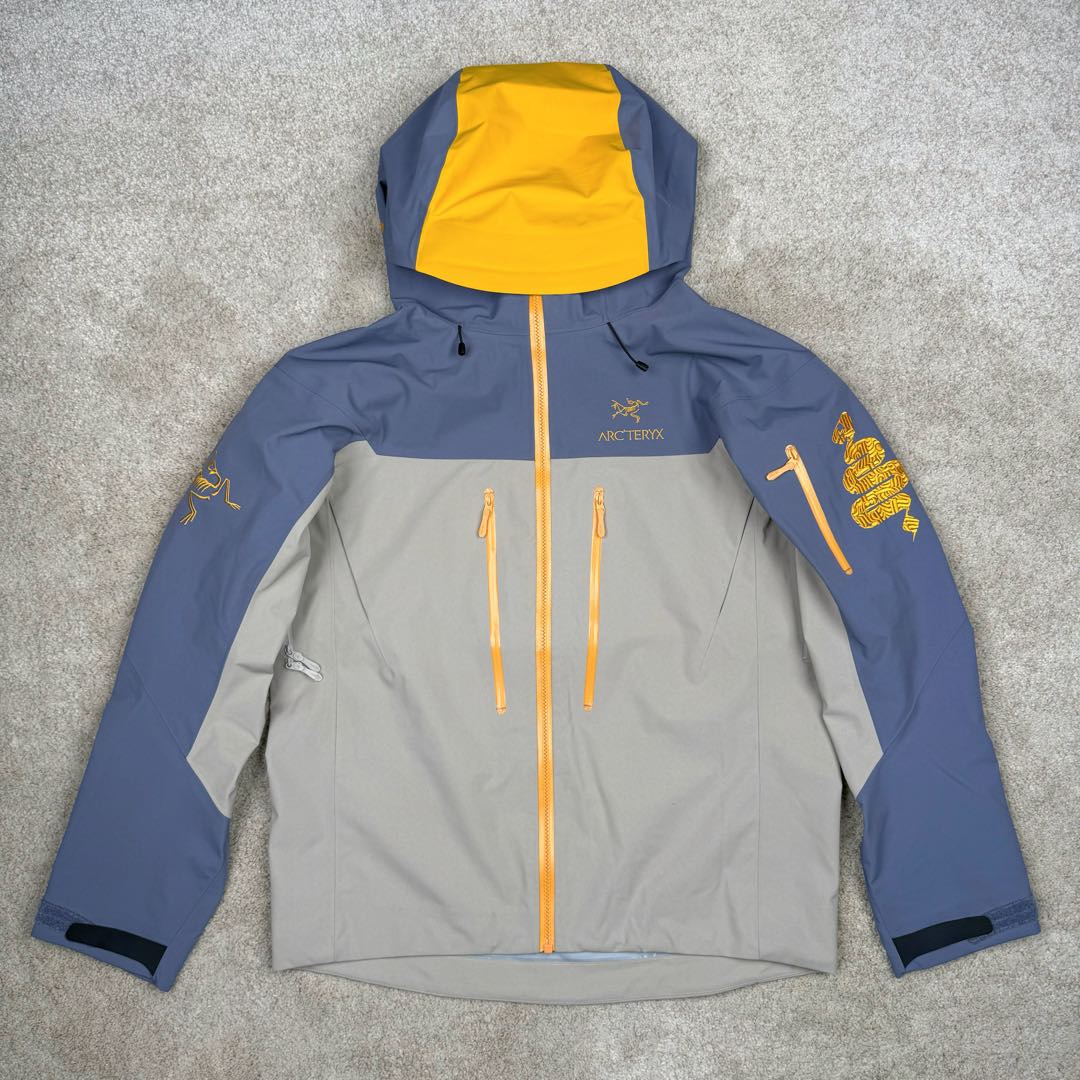 ＃TZD Arcteryx Alpha SV 7 GORE-TEX Pro 始祖鸟第七代刺绣Logo图案休闲运动连帽拉链硬壳户外远足防水冲锋衣 蛇年限定 台州顶级批次 现货供应众所周日每年始祖鸟都会以十二生肖为思路出一款联名款的新年限定，今年也不例外此次的蛇年限定胸口logo为金标衣袖上的蛇形图案也很吸睛帽子上还有蛇鳞为点缀整个衣服的颜色为金黄-深蓝-棕整体看上去很亮设计感拉满 颜色搭配也很好! – Alpha SV JACKET 硬壳限定款Alpha SV JACKET 在袖口和内侧口袋饰有蛇形图案， – 限定款的帽子边缘同样点缀着蛇鳞印花设计 蛇“名”所代表的坚韧精神，正如始祖鸟高山精神所倡导的无畏挑战、勇往直前。 NO1. 防水：防水为国际ISO标准90(ISO4)级别达到荷叶水珠滚动效果! NO2. 面料：采用2L双层Gore-tex面料，面料表层做超高强度防水，内层覆膜，所以到达三层防水的效果，使成衣具有防水防污透气的出色效果。 NO3. 工艺：压胶采用的胶水为铁金刚胶条，市面销售的潜水服就是这个牌子的胶水，区别市面普通压胶(洗几次就开胶)咱家只管放心 NO4. 刺绣：进口百灵达刺绣机还原ZP。百灵达刺绣工整立体，饱满度立体感以及每个字母的神韵特点，一笔一划工工整整立体效果强烈 NO5. 辅料：原版正品五金配件，字体清晰立体与正品一致 尺码：S M L XL XXL-选品中心