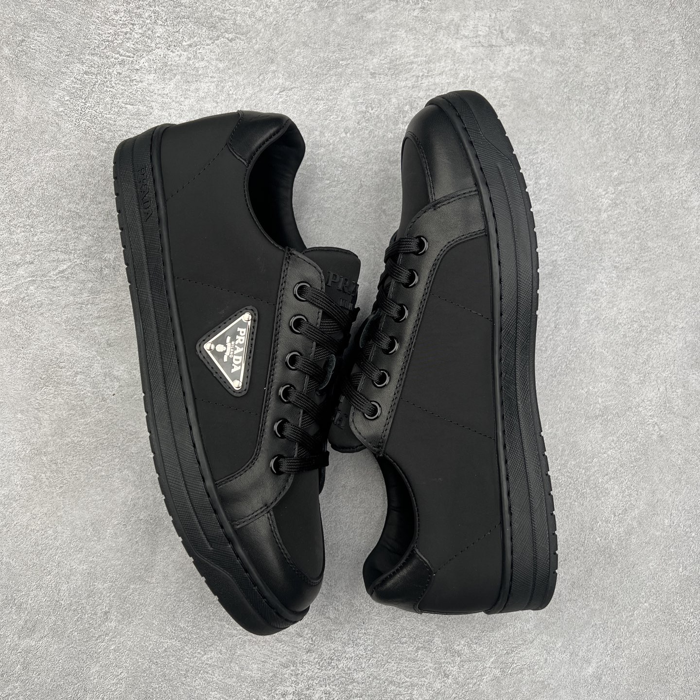 图片[3]-＃纯原 普拉达Prada Downtown Low Sneakers 闹市区系列低帮系带百搭休闲运动小白板鞋“皮革黑白熊猫三角标”男鞋广东原产#原楦数据开发版型#采用粒面头层牛皮鞋面材质#内嵌灌注式PU乳胶缓震鞋垫#外置3.5cmTPR抽真空橡胶鞋底 标志性的珐琅三角形金属徽标，意大利高奢品牌 这款皮革运动鞋多角度诠释Prada徽标：轻巧跃于鞋舌，沿轻质橡胶鞋底铺陈，化身标志性的涂珐琅金属三角形点缀鞋面一侧，无不阐释品牌格调。金属孔眼和棉质鞋带 珐琅三角形装饰鞋面 鞋舌Prada Milano印花徽标 轻质箱型鞋底，侧面配压花徽标 鞋底厚3.5厘米 可拆卸皮革包覆内底 尺码 38 39 40 41 42 43 44 45-选品中心