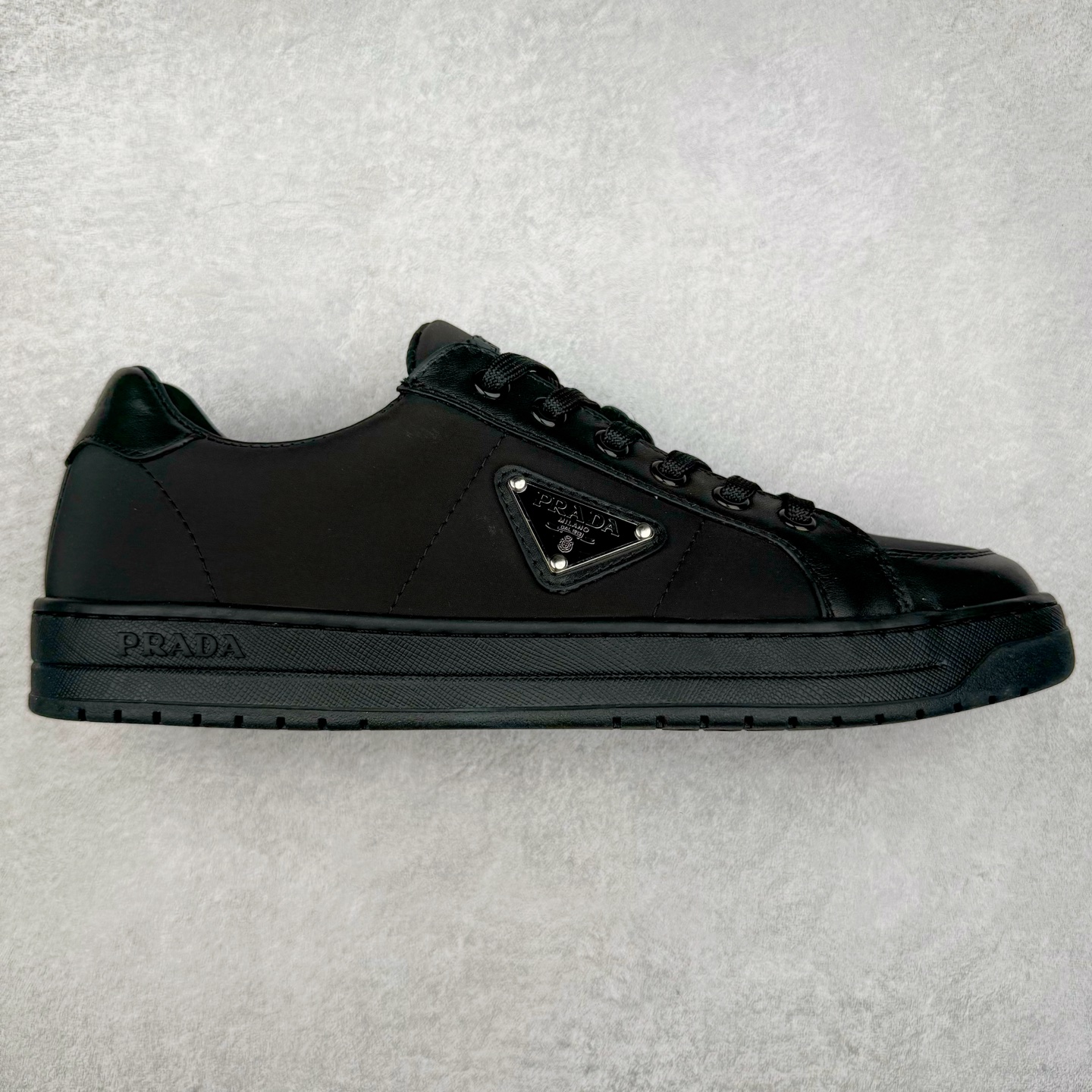 ＃纯原 普拉达Prada Downtown Low Sneakers 闹市区系列低帮系带百搭休闲运动小白板鞋“皮革黑白熊猫三角标”男鞋广东原产#原楦数据开发版型#采用粒面头层牛皮鞋面材质#内嵌灌注式PU乳胶缓震鞋垫#外置3.5cmTPR抽真空橡胶鞋底 标志性的珐琅三角形金属徽标，意大利高奢品牌 这款皮革运动鞋多角度诠释Prada徽标：轻巧跃于鞋舌，沿轻质橡胶鞋底铺陈，化身标志性的涂珐琅金属三角形点缀鞋面一侧，无不阐释品牌格调。金属孔眼和棉质鞋带 珐琅三角形装饰鞋面 鞋舌Prada Milano印花徽标 轻质箱型鞋底，侧面配压花徽标 鞋底厚3.5厘米 可拆卸皮革包覆内底 尺码 38 39 40 41 42 43 44 45-选品中心