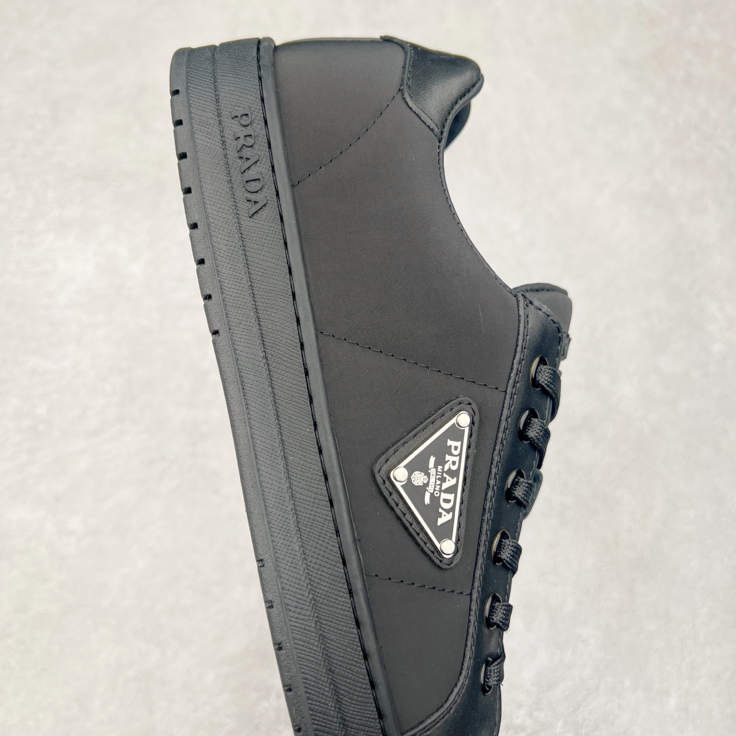 图片[6]-＃纯原 普拉达Prada Downtown Low Sneakers 闹市区系列低帮系带百搭休闲运动小白板鞋“皮革黑白熊猫三角标”男鞋广东原产#原楦数据开发版型#采用粒面头层牛皮鞋面材质#内嵌灌注式PU乳胶缓震鞋垫#外置3.5cmTPR抽真空橡胶鞋底 标志性的珐琅三角形金属徽标，意大利高奢品牌 这款皮革运动鞋多角度诠释Prada徽标：轻巧跃于鞋舌，沿轻质橡胶鞋底铺陈，化身标志性的涂珐琅金属三角形点缀鞋面一侧，无不阐释品牌格调。金属孔眼和棉质鞋带 珐琅三角形装饰鞋面 鞋舌Prada Milano印花徽标 轻质箱型鞋底，侧面配压花徽标 鞋底厚3.5厘米 可拆卸皮革包覆内底 尺码 38 39 40 41 42 43 44 45-选品中心