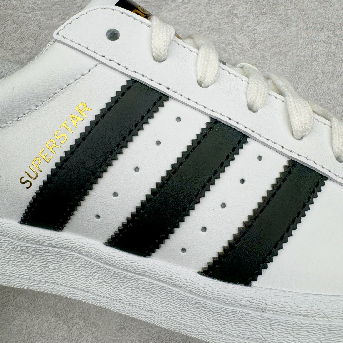 图片[17]-＃G版 AD Originals Superstar 经典贝壳头休闲板鞋 白黑 EG4958 市面最完美的贝壳头版型 2024全新细节 注意区分旧版 随意对比市面 知名大厂出品 正常个位数利润的单价 百分百全新货品 零氧化发霉 给足利润空间操作 独家控货 平台正单 全套原纸板楦头开发 每道工序同步公司流程 确保原汁原味 完美呈现原鞋版型 原厂高频磨具加持 精准内部资源对接 Logo字体百分百还原 全鞋电脑针车 Logo针车间距针数原版一致 皮料切割冲裁零瑕疵 原鞋一致含胶量超耐磨大底 大几率过验 不对比市面只对比原鞋 只服务最高端市场 诞生于1969年 是第一双将全皮面鞋 身与橡胶鞋头结合在一起的低帮篮球鞋 Superstar最开始 是作为高帮篮球鞋Pro Model的低帮版本而出现的 但因为其独特和醒目的橡胶鞋头造型而让大家熟知 被大家形象地称为\\\”shelltoe\\\”贝壳头 在70年代的美国职业篮球场上 接近3/4的NBA球员都将这双Superstar作为场上用鞋 80年代之后 经过不断的改良和发展 Superstar逐渐成为横跨时装、音乐、街头文化、休闲和运动等各大领域的时尚潮鞋 尺码：35.5 36 36.5 37 38 38.5 39 40 40.5 41 42 42.5 43 44 44.5 45 46-选品中心