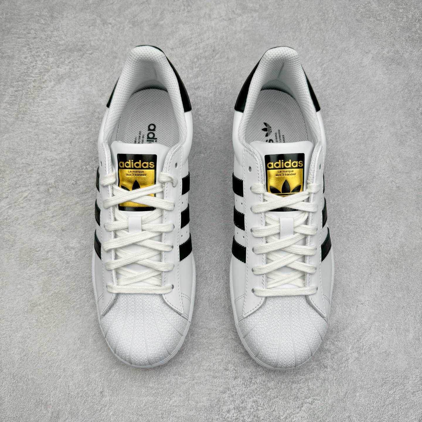 图片[2]-＃G版 AD Originals Superstar 经典贝壳头休闲板鞋 白黑 EG4958 市面最完美的贝壳头版型 2024全新细节 注意区分旧版 随意对比市面 知名大厂出品 正常个位数利润的单价 百分百全新货品 零氧化发霉 给足利润空间操作 独家控货 平台正单 全套原纸板楦头开发 每道工序同步公司流程 确保原汁原味 完美呈现原鞋版型 原厂高频磨具加持 精准内部资源对接 Logo字体百分百还原 全鞋电脑针车 Logo针车间距针数原版一致 皮料切割冲裁零瑕疵 原鞋一致含胶量超耐磨大底 大几率过验 不对比市面只对比原鞋 只服务最高端市场 诞生于1969年 是第一双将全皮面鞋 身与橡胶鞋头结合在一起的低帮篮球鞋 Superstar最开始 是作为高帮篮球鞋Pro Model的低帮版本而出现的 但因为其独特和醒目的橡胶鞋头造型而让大家熟知 被大家形象地称为\\\”shelltoe\\\”贝壳头 在70年代的美国职业篮球场上 接近3/4的NBA球员都将这双Superstar作为场上用鞋 80年代之后 经过不断的改良和发展 Superstar逐渐成为横跨时装、音乐、街头文化、休闲和运动等各大领域的时尚潮鞋 尺码：35.5 36 36.5 37 38 38.5 39 40 40.5 41 42 42.5 43 44 44.5 45 46-选品中心