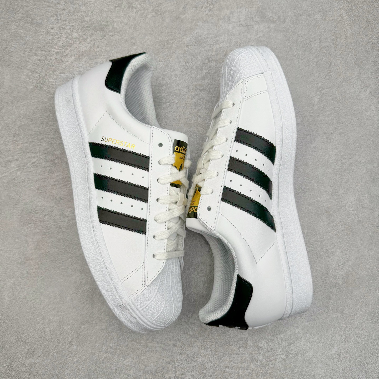 图片[3]-＃G版 AD Originals Superstar 经典贝壳头休闲板鞋 白黑 EG4958 市面最完美的贝壳头版型 2024全新细节 注意区分旧版 随意对比市面 知名大厂出品 正常个位数利润的单价 百分百全新货品 零氧化发霉 给足利润空间操作 独家控货 平台正单 全套原纸板楦头开发 每道工序同步公司流程 确保原汁原味 完美呈现原鞋版型 原厂高频磨具加持 精准内部资源对接 Logo字体百分百还原 全鞋电脑针车 Logo针车间距针数原版一致 皮料切割冲裁零瑕疵 原鞋一致含胶量超耐磨大底 大几率过验 不对比市面只对比原鞋 只服务最高端市场 诞生于1969年 是第一双将全皮面鞋 身与橡胶鞋头结合在一起的低帮篮球鞋 Superstar最开始 是作为高帮篮球鞋Pro Model的低帮版本而出现的 但因为其独特和醒目的橡胶鞋头造型而让大家熟知 被大家形象地称为\\\”shelltoe\\\”贝壳头 在70年代的美国职业篮球场上 接近3/4的NBA球员都将这双Superstar作为场上用鞋 80年代之后 经过不断的改良和发展 Superstar逐渐成为横跨时装、音乐、街头文化、休闲和运动等各大领域的时尚潮鞋 尺码：35.5 36 36.5 37 38 38.5 39 40 40.5 41 42 42.5 43 44 44.5 45 46-选品中心