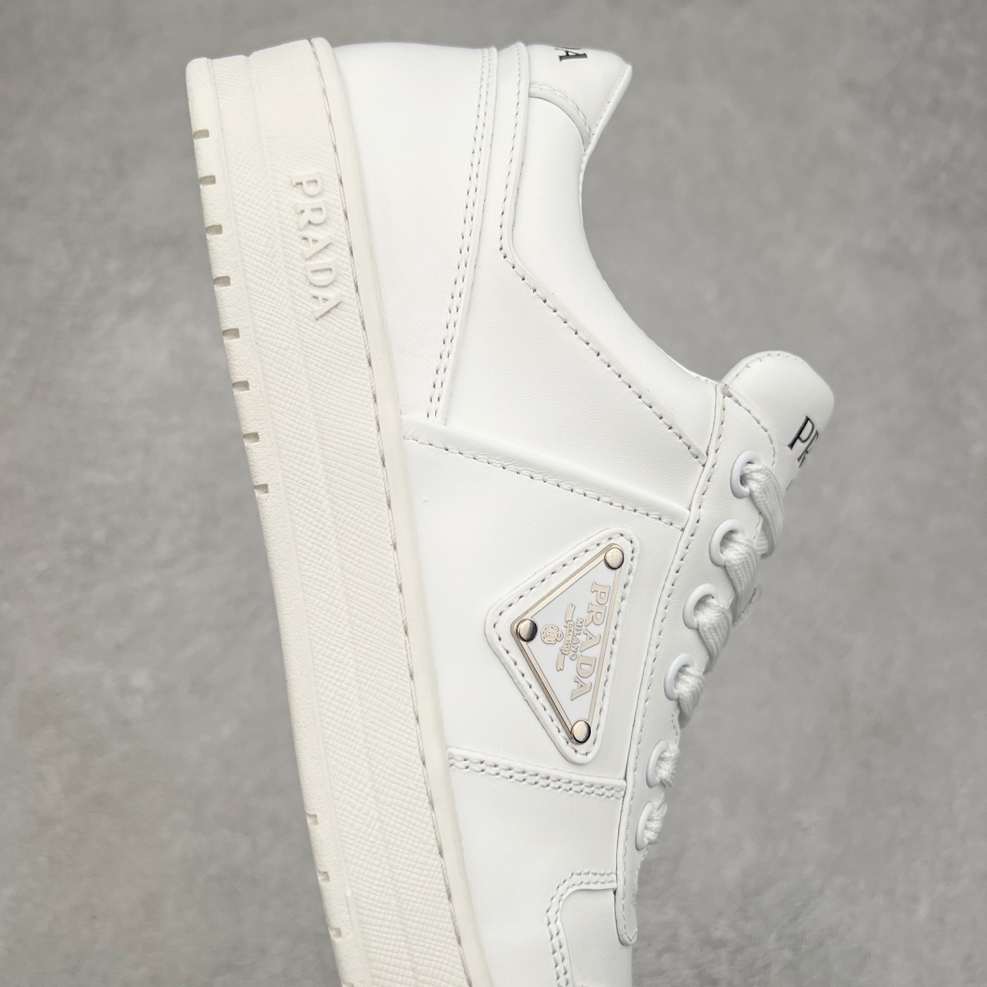 图片[6]-＃纯原 普拉达Prada Downtown Low Sneakers 闹市区系列低帮系带百搭休闲运动小白板鞋“皮革黑白熊猫三角标”男鞋广东原产#原楦数据开发版型#采用粒面头层牛皮鞋面材质#内嵌灌注式PU乳胶缓震鞋垫#外置3.5cmTPR抽真空橡胶鞋底 标志性的珐琅三角形金属徽标，意大利高奢品牌 这款皮革运动鞋多角度诠释Prada徽标：轻巧跃于鞋舌，沿轻质橡胶鞋底铺陈，化身标志性的涂珐琅金属三角形点缀鞋面一侧，无不阐释品牌格调。金属孔眼和棉质鞋带 珐琅三角形装饰鞋面 鞋舌Prada Milano印花徽标 轻质箱型鞋底，侧面配压花徽标 鞋底厚3.5厘米 可拆卸皮革包覆内底 尺码 38 39 40 41 42 43 44 45-选品中心