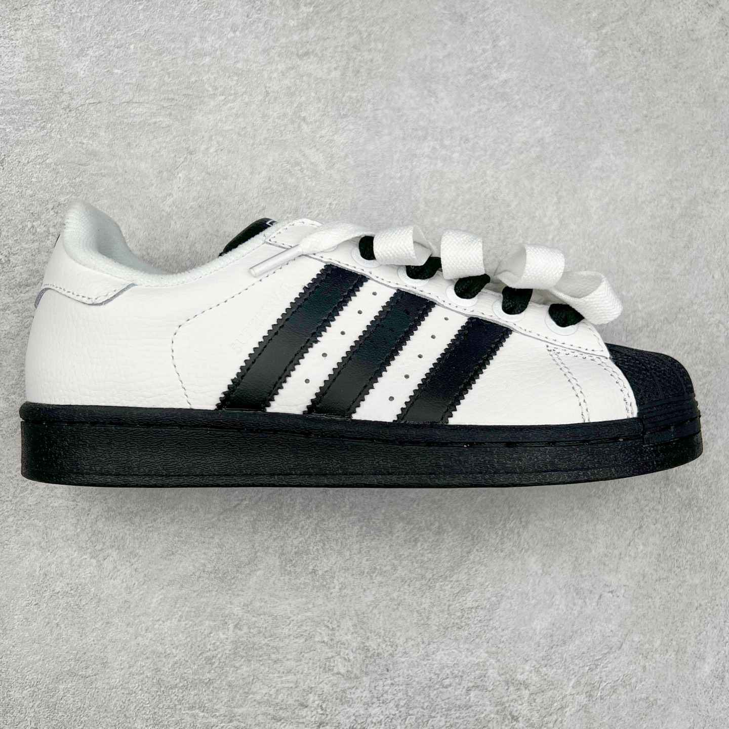 AD Originals Superstar 经典复古贝壳头板鞋 JI0124 诞生于1969年 是第一双将全皮面鞋 身与橡胶鞋头结合在一起的低帮篮球鞋 Superstar最开始 是作为高帮篮球鞋Pro Model的低帮版本而出现的 但因为其独特和醒目的橡胶鞋头造型而让大家熟知 被大家形象地称为\\\