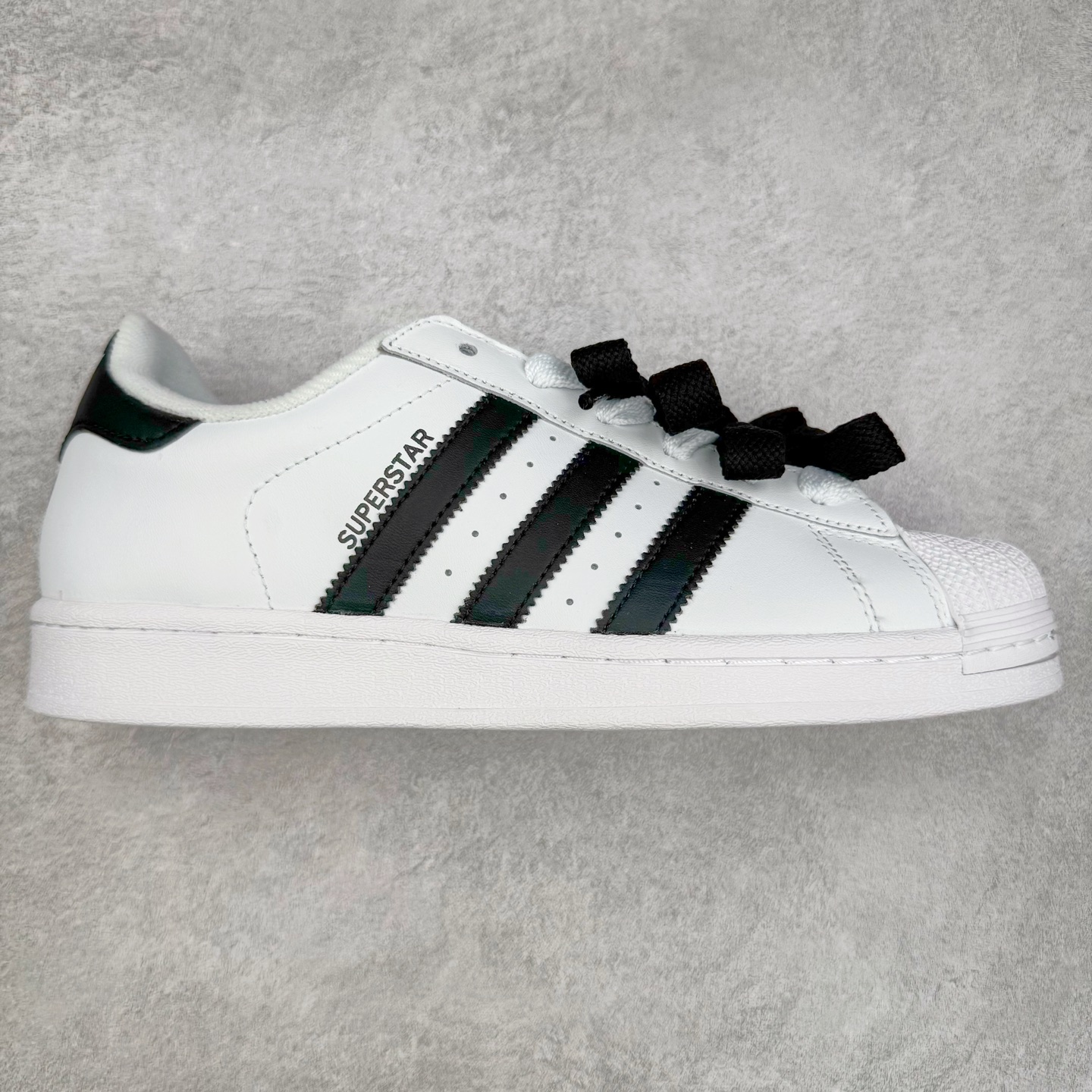 AD Originals Superstar 经典复古贝壳头板鞋 IH8659 诞生于1969年 是第一双将全皮面鞋 身与橡胶鞋头结合在一起的低帮篮球鞋 Superstar最开始 是作为高帮篮球鞋Pro Model的低帮版本而出现的 但因为其独特和醒目的橡胶鞋头造型而让大家熟知 被大家形象地称为\\\