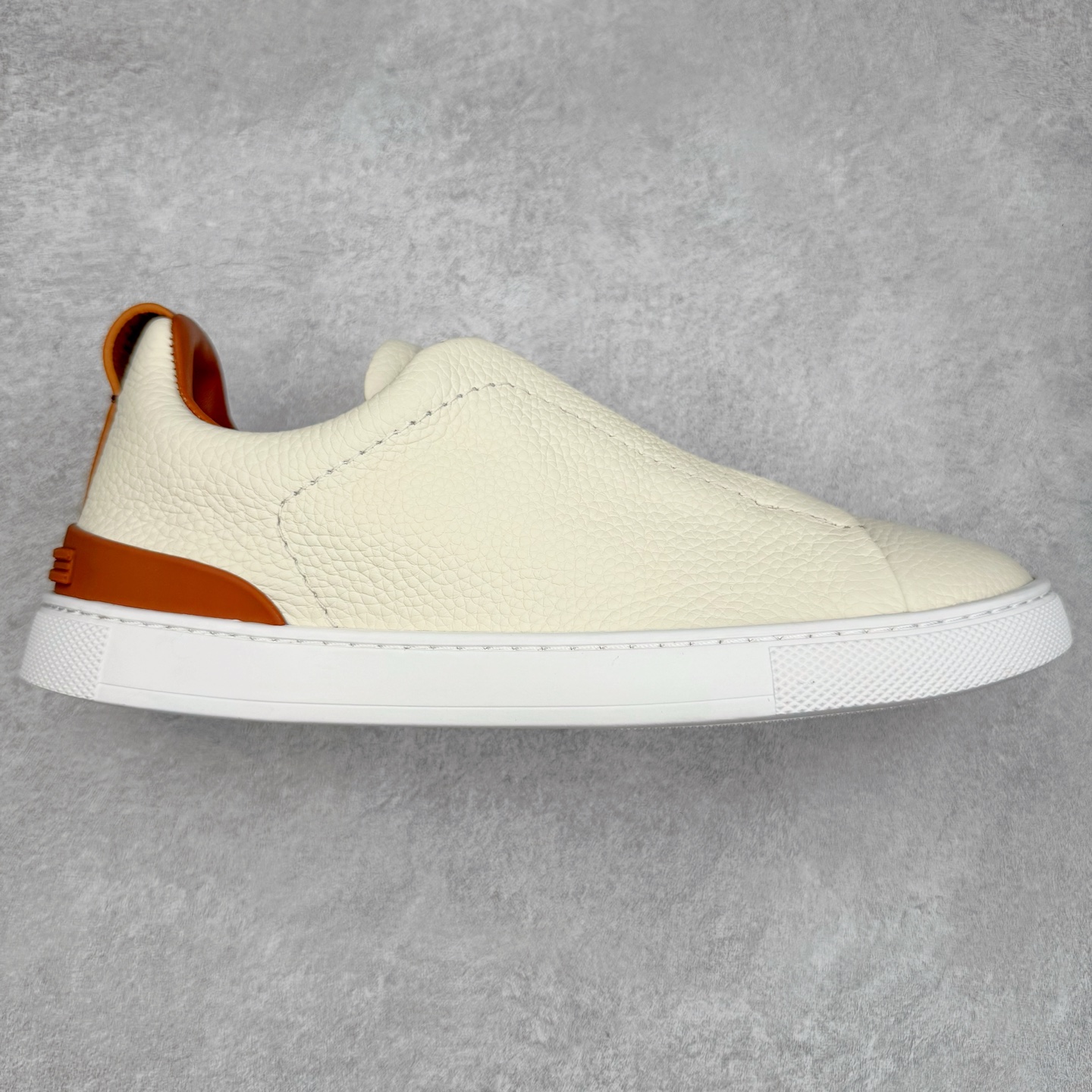 ＃零售版 Zegna Triple Stitch 杰尼亚皮革 圆头平底 低帮低帮运动鞋 摔花纹牛皮制成，饰以丰富的工艺细节，如骆马红棕色皮革嵌饰和手绘饰边。此优雅材质令这款动感十足的运动鞋转变为精致的休闲单品。耐用的橡胶鞋底可探索城市街道提供所有需的支持。版型和产品细节：摔花纹牛皮面料，双色宽罗纹针织鞋带满足不同场合搭配不同风格，小牛皮内裡，鞋垫。内底、徽标压纹皮革中底，高弹力记忆鞋垫和超轻橡胶人字纹防滑鞋底，穿着舒服不凡。鞋底周圈加车大底边线。显得匠心十足。尺码：39 40 41 42 43 44 45 46-选品中心