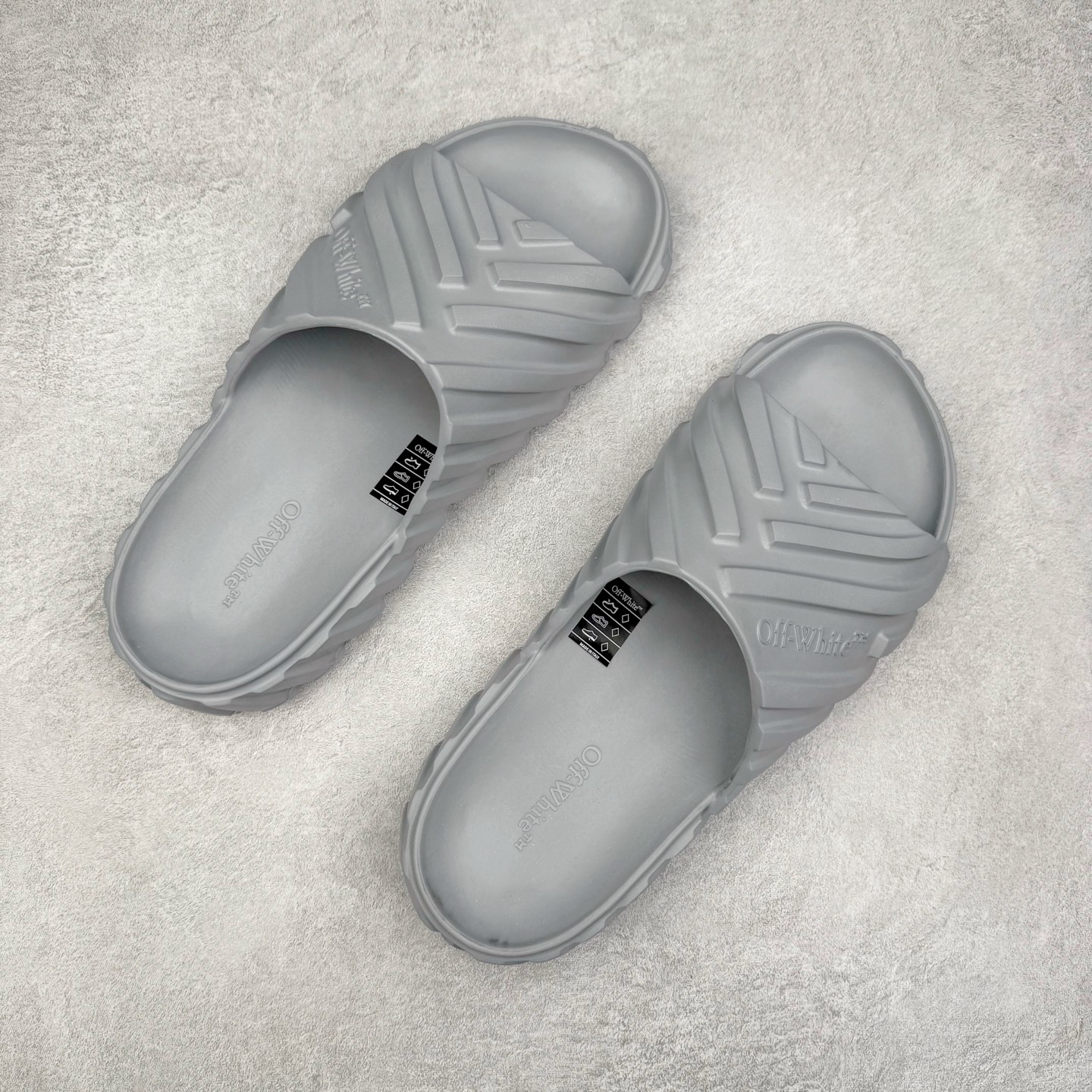 图片[3]-OFF-WHITE OW露趾套脚 EVA一字拖鞋 Off-White由才华横溢的Virgil Abloh于2013年创立。这位美国设计师既是建筑系硕士生 也是一名DJ，更是著名的Kanye West的创意总监。他以都市奢华风格惊艳了众人，并且“以典雅方法演绎当代风尚”，设计出一件又一件备受追捧的作品。Off-White别具特色的卫衣、腰带、夹克、T恤等单品俨然已成为了时尚的代名词。前卫潮流的设计、充满趣味的细节以及别出心裁的剪裁使Off-White传达出浓厚的时尚气质，是打造摩登造型不容忽视的品牌。尺码：40 41 42 43 44 45-选品中心