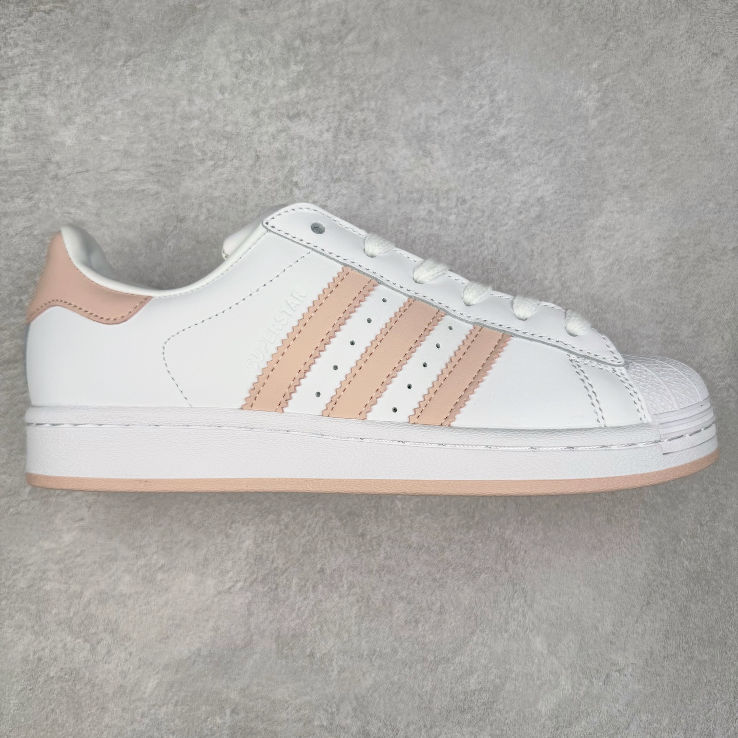 AD Originals Superstar 经典复古贝壳头板鞋 JH7056 诞生于1969年 是第一双将全皮面鞋 身与橡胶鞋头结合在一起的低帮篮球鞋 Superstar最开始 是作为高帮篮球鞋Pro Model的低帮版本而出现的 但因为其独特和醒目的橡胶鞋头造型而让大家熟知 被大家形象地称为\\\