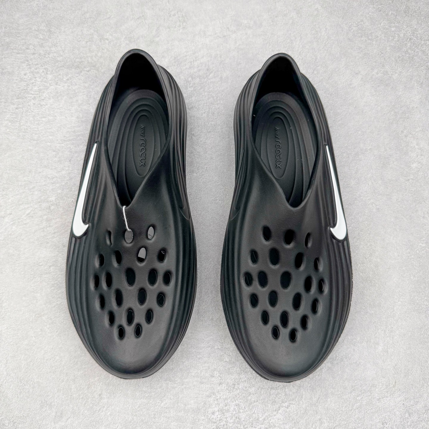 图片[2]-＃Lw纯原 NK ReactX Rejuven8 简约舒适百搭洞洞鞋 FV5060-001 重金购入原鞋及原档案磨具生产指令开发 唯一正确组合大底 组合侧面Logo 鞋头不过分上翘 后跟Logo 凹凸明显 轮廓分明 LOGO内侧钢印清晰工整 原厂磨具全鞋无多余毛边 同源公司EVA粒子环保塑料 原厂指令配方 无任何异味 弹性卡色均保持原鞋一致 匠心打造 鞋口弧度大小 鞋面色泽质感同步原鞋 LOGO内侧钢印清晰工整 从名字就能看出，这款鞋搭载了React X缓震科技，保证了舒适的脚感和轻盈的穿着体验。设计上，这双鞋采用了近几年非常流行的洞洞鞋风格，但特别之处在于加入了波浪纹路细节，让整个鞋型看起来更有立体感，视觉上也增添了几分现代感。尺码：36 36.5 37.5 38 38.5 39 40 40.5 41 42 42.5 43 44 44.5 45 46.5 47.5 48.5-选品中心