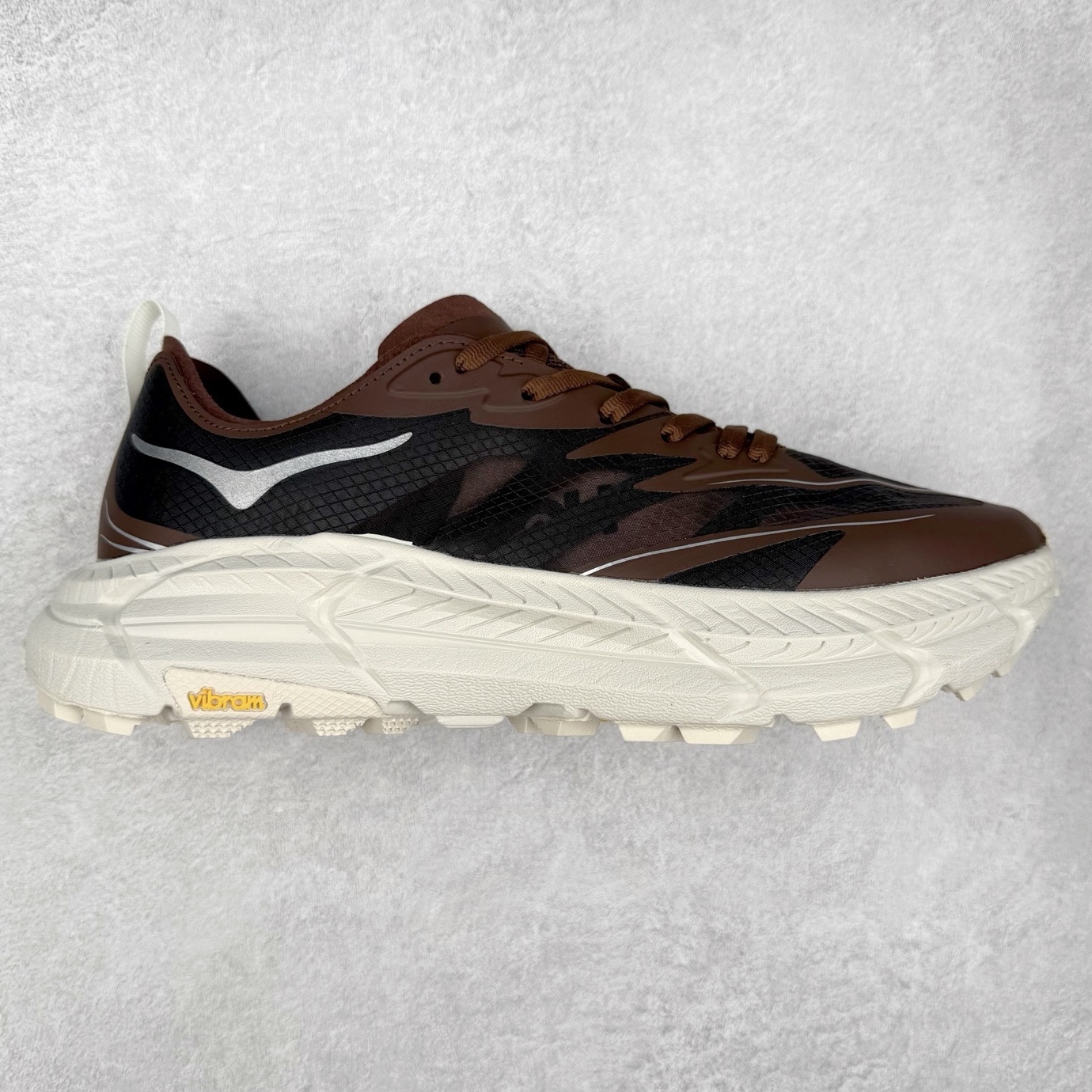 Satisfy x HOKA ONE ONE 百搭简约防滑耐磨低帮跑步鞋 联名配色 球鞋继承了HOKA的经典越野鞋型MAFATE SPEED 4的设计，更在此基础上进行了创新和提升，使得它既适合户外越野跑，又充满了时尚潮流的元素。它的半透明鞋面设计，不仅让鞋身看起来更加轻便，而且提供了良好的透气性。而保护性的防撕裂尼龙面料，则确保了在复杂地形中的耐用性。这样的设计，让人在享受奔跑的同时，也能感受到鞋底带来的舒适。双层ProFly™中底的使用，是这款鞋的另一个亮点。这种中底材质，提供了卓越的缓震性能，无论是在崎岖的山路上，还是在平坦的道路上，都能给跑者带来稳定的支撑。而VIBRAM MEGAGRIP®及LITEBASE®大底的搭载，更是让这款鞋在保持高抓地力的同时，减轻了鞋底的重量，使得每一步跑动都轻盈如飞。尺码：36 36.5 37.5 38 38.5 39 40 40.5 41 42 42.5 43 44 44.5 45 46-选品中心