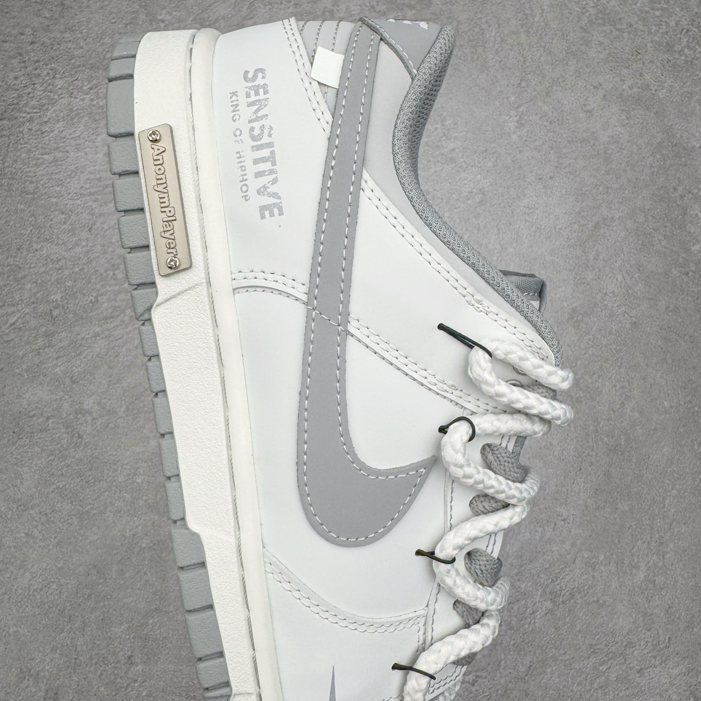 图片[6]-＃YC纯原 NK Dunk Low 无冕之王 WG0508-040 此款以极简白魂打底，磨砂质感拼接哑光皮革，视觉层次如双押韵脚，灰色Swoosh划破旋律爆点，不张扬，却藏不住高级感。粗粝绑绳诠释解构美学，致敬街头文化反叛精神。后跟「KING OF HIPHOP」烙印宣言，致敬地下舞台的隐形冠军。定制系列天花板 无原鞋不开发 全系列得物原鞋一比一校对开发 配色持续更新中 终端对接 优势输出 全套原厂楦头原纸板数据档案倾力打造 原汁原味莞产 极致还原 圈内最强针车工艺 高端零售指定版 广东原厂配套原盒原标 鞋盒分三个尺码段 原厂冲刀 超高清洁度 全鞋零毛边皮料切割 采用原厂百宏鞋带以及原厂百宏织唛舌标 内标可供原厂几率过验 进口原装条纹中底布 四线拉帮白色点胶 原厂拉帮手法遵循公司 原厂电绣 极致还原 尺码：36 36.5 37.5 38 38.5 39 40 40.5 41 42 42.5 43 44 44.5 45 46-选品中心