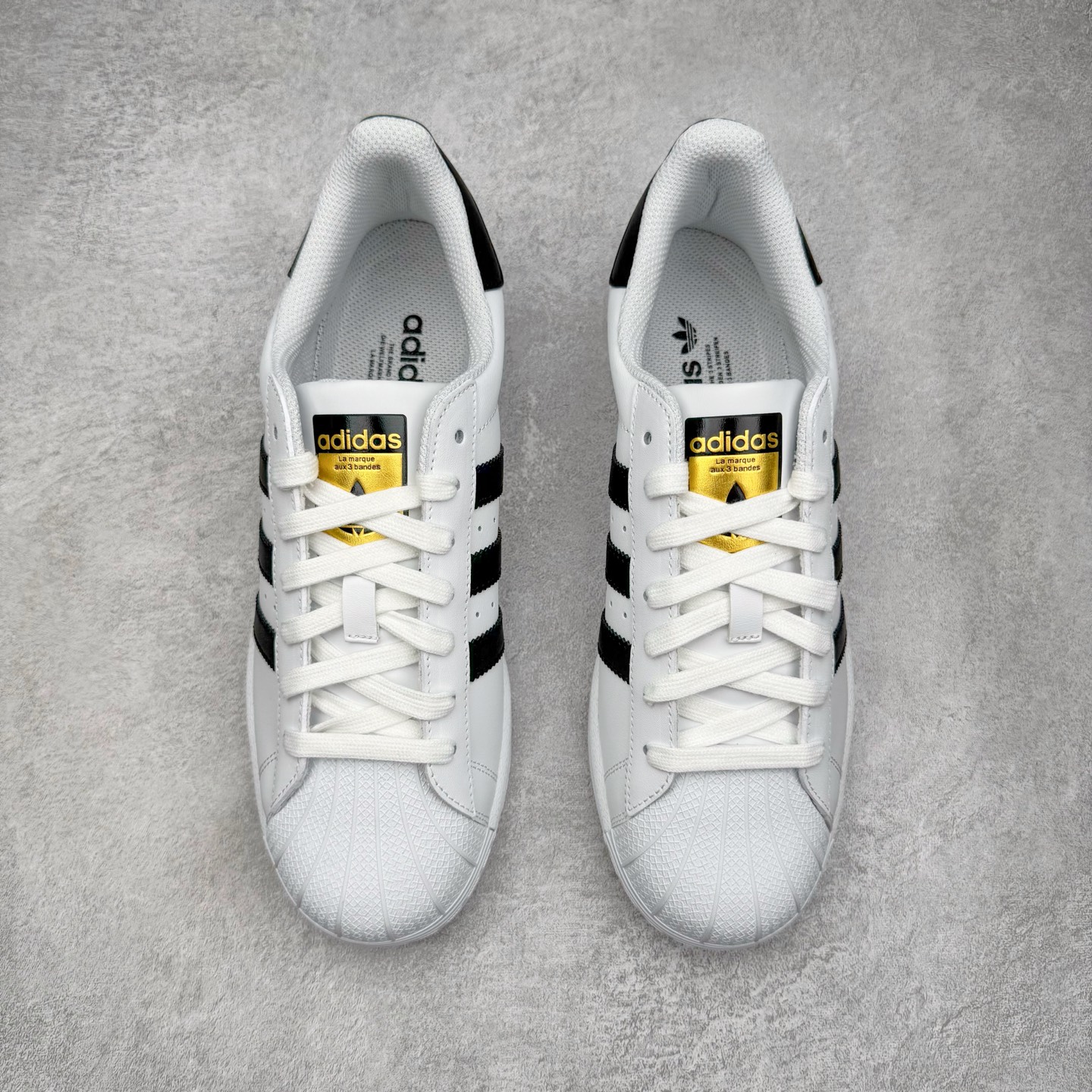 图片[2]-＃G版纯原 AD Originals Superstar 经典贝壳头休闲板鞋 EG4958 市面最完美的贝壳头版型 2024全新细节 注意区分旧版 随意对比市面 知名大厂出品 工厂个位数利润的单价 百分百全新货品 零氧化发霉 给足利润空间操作 独家控货 平台正单 全套原纸板楦头开发 每道工序同步公司流程 确保原汁原味 完美呈现原鞋版型 原厂高频磨具加持 精准内部资源对接 Logo字体百分百还原 全鞋电脑针车 Logo针车间距针数原版一致 皮料切割冲裁零瑕疵 原鞋一致含胶量超耐磨大底 大几率过验 不对比市面只对比原鞋 只服务最高端市场 诞生于1969年 是第一双将全皮面鞋 身与橡胶鞋头结合在一起的低帮篮球鞋 Superstar最开始 是作为高帮篮球鞋Pro Model的低帮版本而出现的 但因为其独特和醒目的橡胶鞋头造型而让大家熟知 被大家形象地称为\\\”shelltoe\\\”贝壳头 在70年代的美国职业篮球场上 接近3/4的NBA球员都将这双Superstar作为场上用鞋 80年代之后 经过不断的改良和发展 Superstar逐渐成为横跨时装、音乐、街头文化、休闲和运动等各大领域的时尚潮鞋 尺码：36 36.5 37 38 38.5 39 40 40.5 41 42 42.5 43 44 44.5 45 46-选品中心