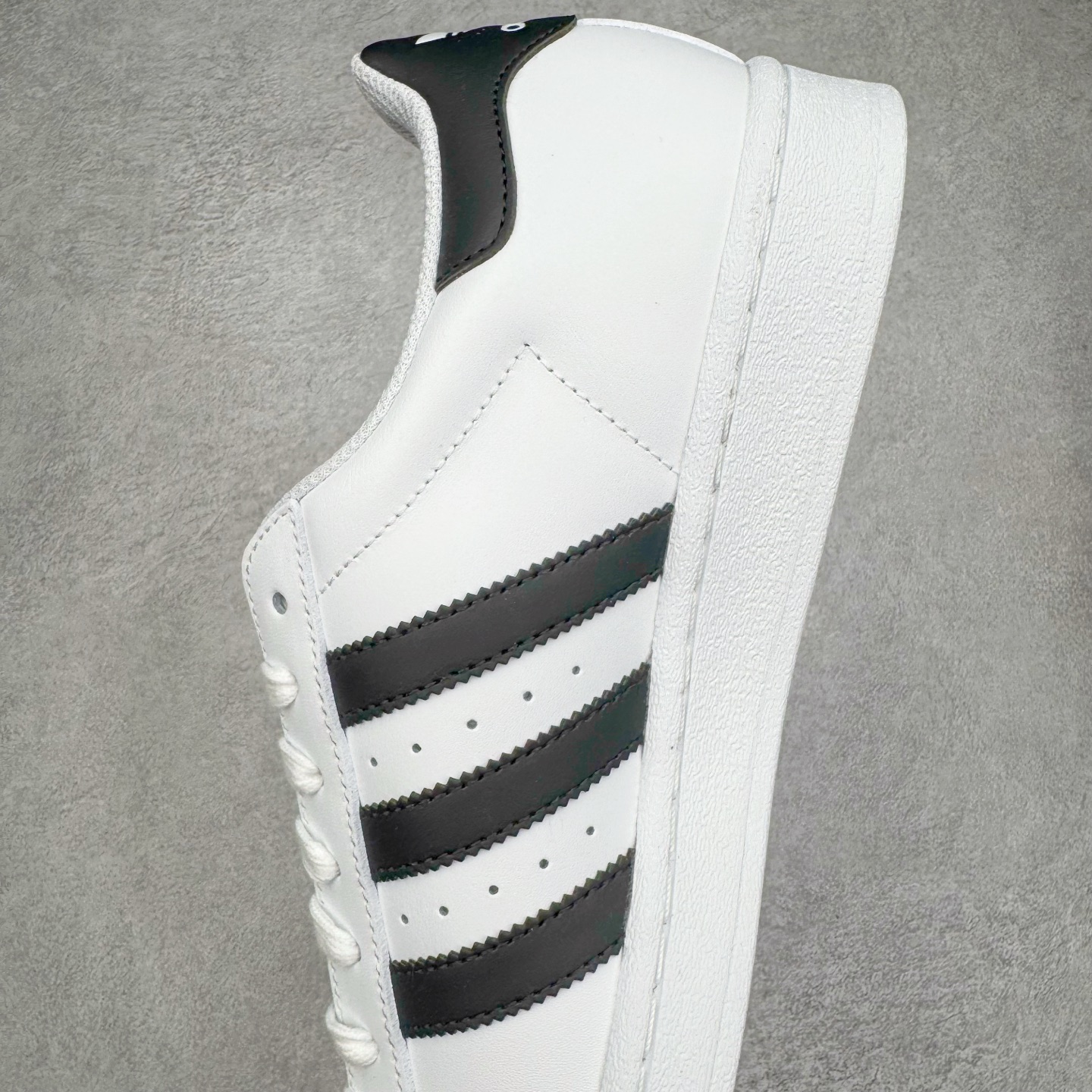 图片[7]-＃G版纯原 AD Originals Superstar 经典贝壳头休闲板鞋 EG4958 市面最完美的贝壳头版型 2024全新细节 注意区分旧版 随意对比市面 知名大厂出品 工厂个位数利润的单价 百分百全新货品 零氧化发霉 给足利润空间操作 独家控货 平台正单 全套原纸板楦头开发 每道工序同步公司流程 确保原汁原味 完美呈现原鞋版型 原厂高频磨具加持 精准内部资源对接 Logo字体百分百还原 全鞋电脑针车 Logo针车间距针数原版一致 皮料切割冲裁零瑕疵 原鞋一致含胶量超耐磨大底 大几率过验 不对比市面只对比原鞋 只服务最高端市场 诞生于1969年 是第一双将全皮面鞋 身与橡胶鞋头结合在一起的低帮篮球鞋 Superstar最开始 是作为高帮篮球鞋Pro Model的低帮版本而出现的 但因为其独特和醒目的橡胶鞋头造型而让大家熟知 被大家形象地称为\\\”shelltoe\\\”贝壳头 在70年代的美国职业篮球场上 接近3/4的NBA球员都将这双Superstar作为场上用鞋 80年代之后 经过不断的改良和发展 Superstar逐渐成为横跨时装、音乐、街头文化、休闲和运动等各大领域的时尚潮鞋 尺码：36 36.5 37 38 38.5 39 40 40.5 41 42 42.5 43 44 44.5 45 46-选品中心