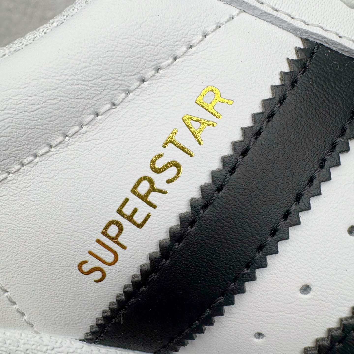 图片[16]-＃G版纯原 AD Originals Superstar 经典贝壳头休闲板鞋 EG4958 市面最完美的贝壳头版型 2024全新细节 注意区分旧版 随意对比市面 知名大厂出品 工厂个位数利润的单价 百分百全新货品 零氧化发霉 给足利润空间操作 独家控货 平台正单 全套原纸板楦头开发 每道工序同步公司流程 确保原汁原味 完美呈现原鞋版型 原厂高频磨具加持 精准内部资源对接 Logo字体百分百还原 全鞋电脑针车 Logo针车间距针数原版一致 皮料切割冲裁零瑕疵 原鞋一致含胶量超耐磨大底 大几率过验 不对比市面只对比原鞋 只服务最高端市场 诞生于1969年 是第一双将全皮面鞋 身与橡胶鞋头结合在一起的低帮篮球鞋 Superstar最开始 是作为高帮篮球鞋Pro Model的低帮版本而出现的 但因为其独特和醒目的橡胶鞋头造型而让大家熟知 被大家形象地称为\\\”shelltoe\\\”贝壳头 在70年代的美国职业篮球场上 接近3/4的NBA球员都将这双Superstar作为场上用鞋 80年代之后 经过不断的改良和发展 Superstar逐渐成为横跨时装、音乐、街头文化、休闲和运动等各大领域的时尚潮鞋 尺码：36 36.5 37 38 38.5 39 40 40.5 41 42 42.5 43 44 44.5 45 46-选品中心