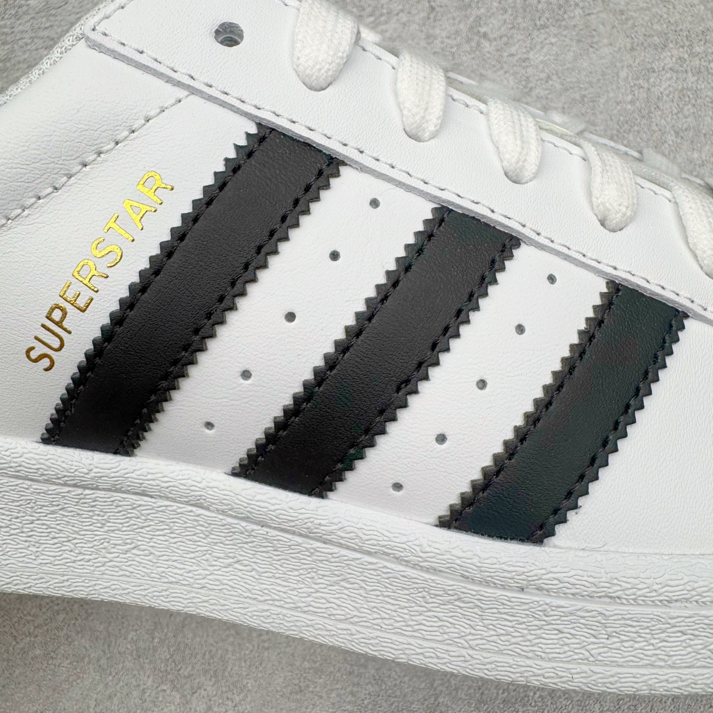图片[17]-＃G版纯原 AD Originals Superstar 经典贝壳头休闲板鞋 EG4958 市面最完美的贝壳头版型 2024全新细节 注意区分旧版 随意对比市面 知名大厂出品 工厂个位数利润的单价 百分百全新货品 零氧化发霉 给足利润空间操作 独家控货 平台正单 全套原纸板楦头开发 每道工序同步公司流程 确保原汁原味 完美呈现原鞋版型 原厂高频磨具加持 精准内部资源对接 Logo字体百分百还原 全鞋电脑针车 Logo针车间距针数原版一致 皮料切割冲裁零瑕疵 原鞋一致含胶量超耐磨大底 大几率过验 不对比市面只对比原鞋 只服务最高端市场 诞生于1969年 是第一双将全皮面鞋 身与橡胶鞋头结合在一起的低帮篮球鞋 Superstar最开始 是作为高帮篮球鞋Pro Model的低帮版本而出现的 但因为其独特和醒目的橡胶鞋头造型而让大家熟知 被大家形象地称为\\\”shelltoe\\\”贝壳头 在70年代的美国职业篮球场上 接近3/4的NBA球员都将这双Superstar作为场上用鞋 80年代之后 经过不断的改良和发展 Superstar逐渐成为横跨时装、音乐、街头文化、休闲和运动等各大领域的时尚潮鞋 尺码：36 36.5 37 38 38.5 39 40 40.5 41 42 42.5 43 44 44.5 45 46-选品中心