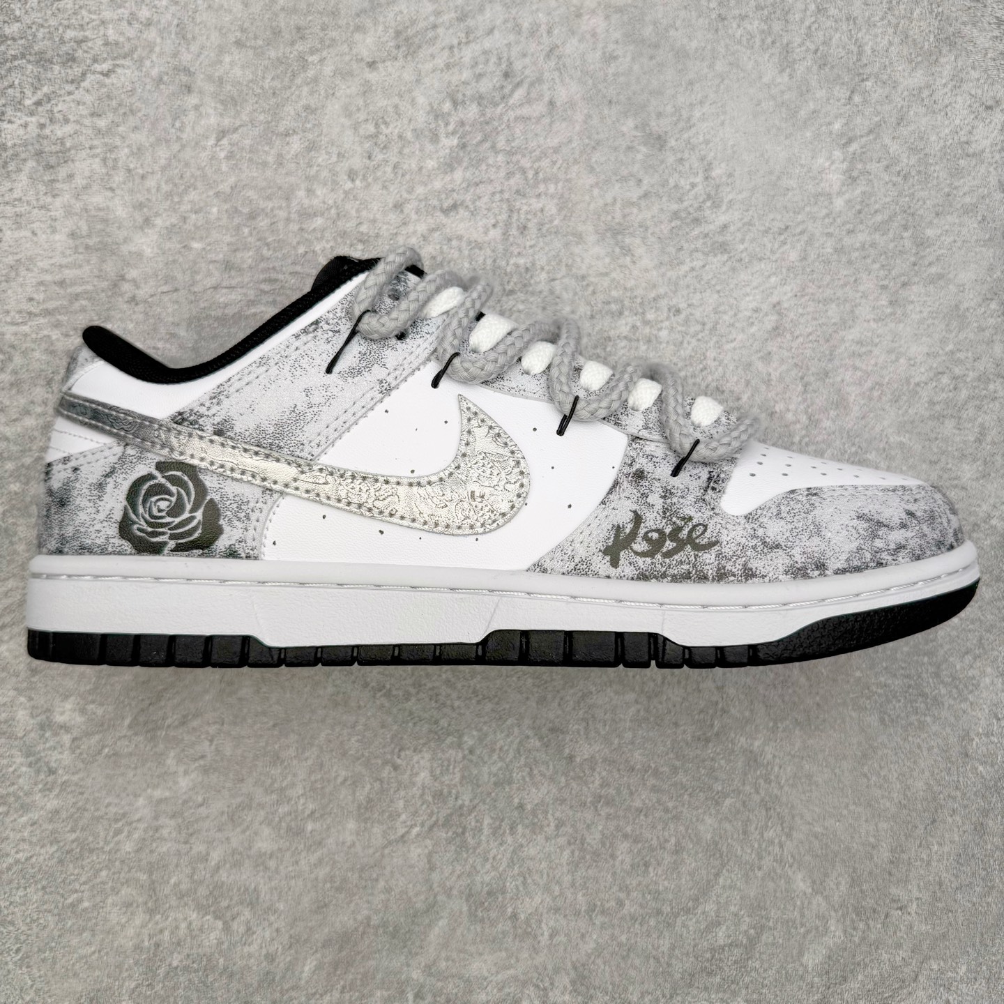 ＃YC纯原 NK Dunk Low 银绽 DD1391-100 银霜为序，玫瑰为诗，当低调的白，邂逅泼墨般的银灰，仿佛寒夜凝结的霜华在鞋面悄然绽放，在光影流转间暗藏层次，呼应「银绽」之名。粗绳鞋带束起利落轮廓，侧身的黑色玫瑰，以暗纹刺绣悄然盛放，注入一抹不羁的浪漫基因。定制系列天花板 无原鞋不开发 全系列得物原鞋一比一校对开发 配色持续更新中 终端对接 优势输出 全套原厂楦头原纸板数据档案倾力打造 原汁原味莞产 极致还原 圈内最强针车工艺 高端零售指定版 广东原厂配套原盒原标 鞋盒分三个尺码段 原厂冲刀 超高清洁度 全鞋零毛边皮料切割 采用原厂百宏鞋带以及原厂百宏织唛舌标 内标可供原厂几率过验 进口原装条纹中底布 四线拉帮白色点胶 原厂拉帮手法遵循公司 原厂电绣 极致还原 SIZE 40 40.5 41 42 42.5 43 44 44.5 45 46-选品中心
