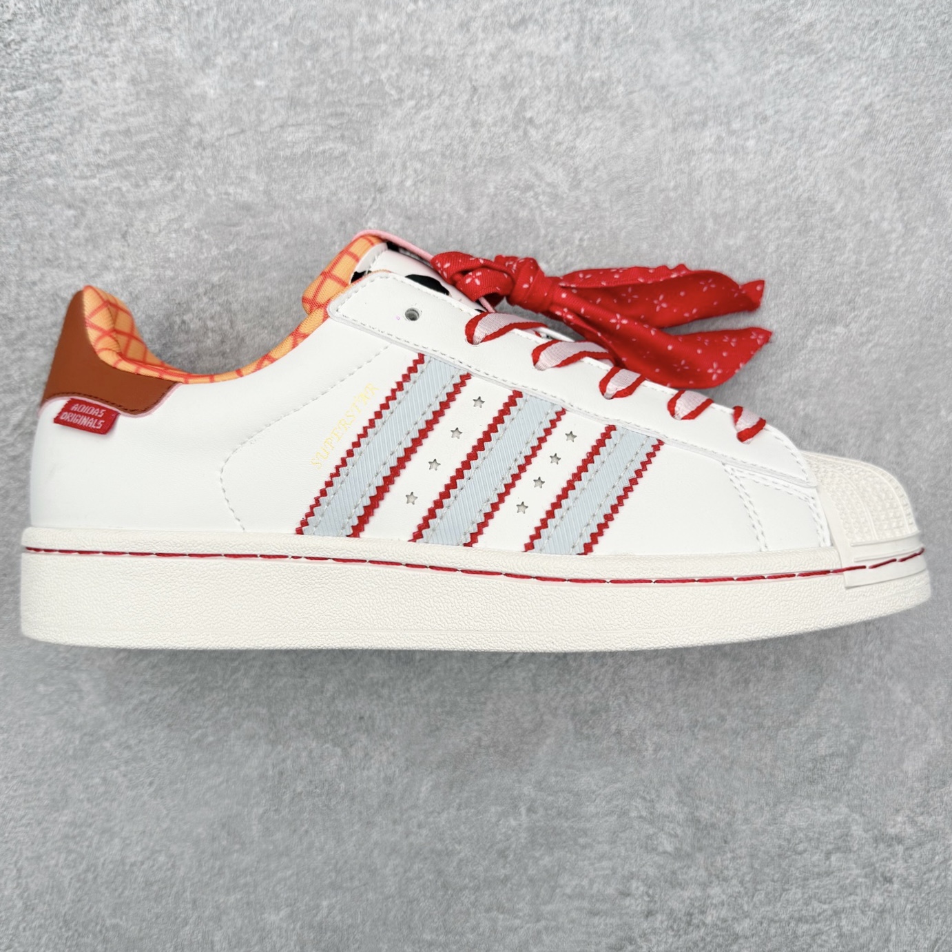 Disney/迪士尼 x AD Originals Superstar 2 贝壳头百搭舒适防滑低帮板鞋 米白红 KK4472 诞生于1969年 是第一双将全皮面鞋 身与橡胶鞋头结合在一起的低帮篮球鞋 Superstar最开始 是作为高帮篮球鞋Pro Model的低帮版本而出现的 但因为其独特和醒目的橡胶鞋头造型而让大家熟知 被大家形象地称为\\\