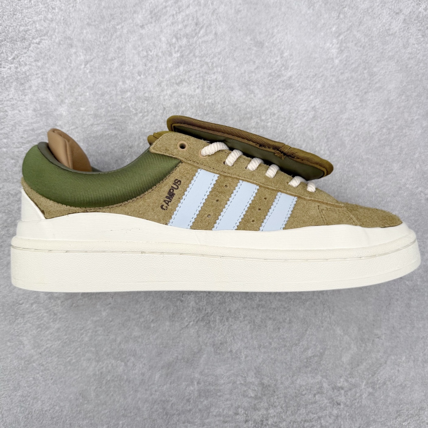 Bad Bunny x AD Campus Light 学院莱特系列低帮复古系带休闲运动板鞋 联名坏痞兔 ID7950 全套原楦原纸板原厂数据开发 原装进口翻毛皮料正确绒感卡色 正确铜制锁扣 原盒原配防尘袋配件 以云白色、米色与和做旧泛黄配色为基调 厚绒麂皮与奢华皮革环绕鞋面 正面看起来无比寻常 但从侧面可以发现双鞋舌和双鞋跟设计提升了观感 鞋中底的重新设计也使得存在感大大增加 更加切合当下时尚 鞋舌和鞋垫上带有 Bad Bunny 的专属标志 并且使用特殊包装彰显其身份 尺码：36 36⅔ 37⅓ 38 38⅔ 39⅓ 40 40⅔ 41⅓ 42 42⅔ 43⅓ 44 45-选品中心