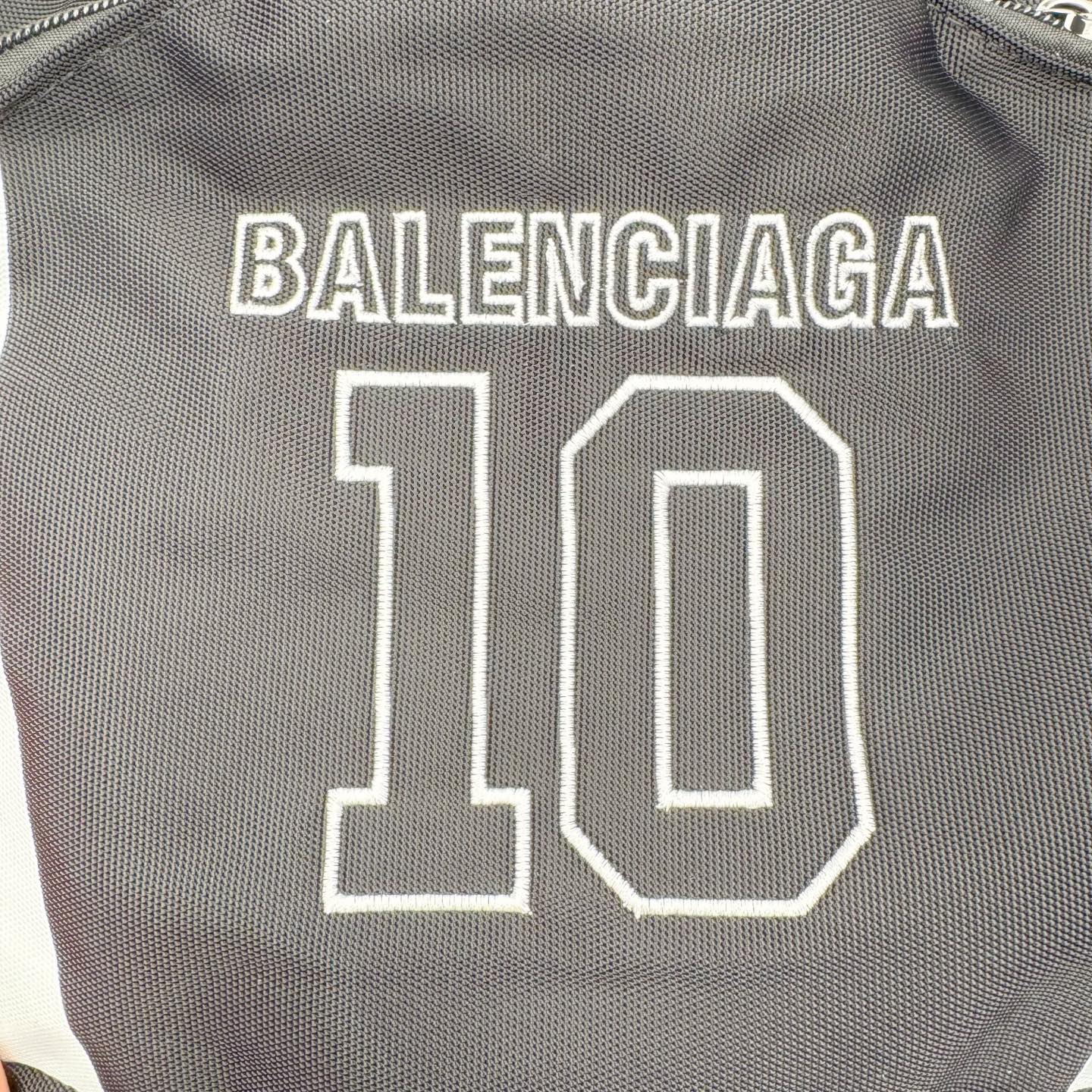 图片[4]-Balenciaga巴黎世家 26年最新款 NBA联名系列 刺绣标识 双肩包 当高奢时尚与篮球文化碰撞，这款双肩包便成了街头与秀场的通行证。 • 设计：以经典黑色尼龙为基底，正面醒目的“BALENCIAGA 10”字样，复刻了球衣号码的热血基因；两侧红白撞色条纹，既是对赛场元素的致敬，也是视觉焦点。 • 细节质感：前置口袋上的NBA官方徽标与BALENCIAGA织标双重认证，从材质到走线，都延续了品牌对工艺的极致追求。 • 风格适配：无论是日常出街、球场边的随性搭配，还是作为潮流收藏，它都能轻松hold住多元场景，让运动精神与高级时装感无缝衔接 材质：高档锦纶帆布 尺寸：48cm*31cm*20cm-选品中心