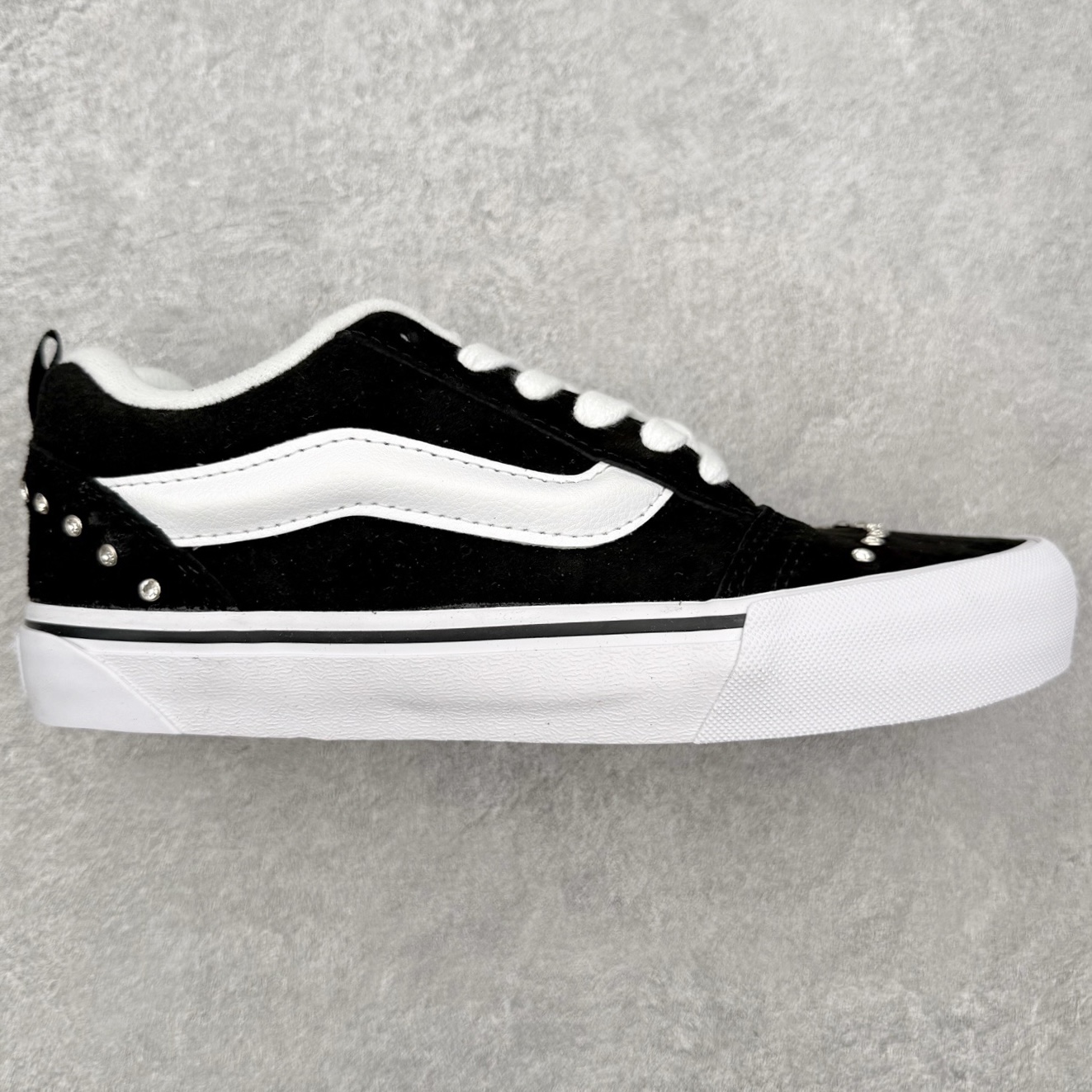 Vans Knu Skool 碎钻铆钉面包鞋此次以碎钻元素为设计亮点，黑白经典配色为基底，全麂皮鞋面搭配