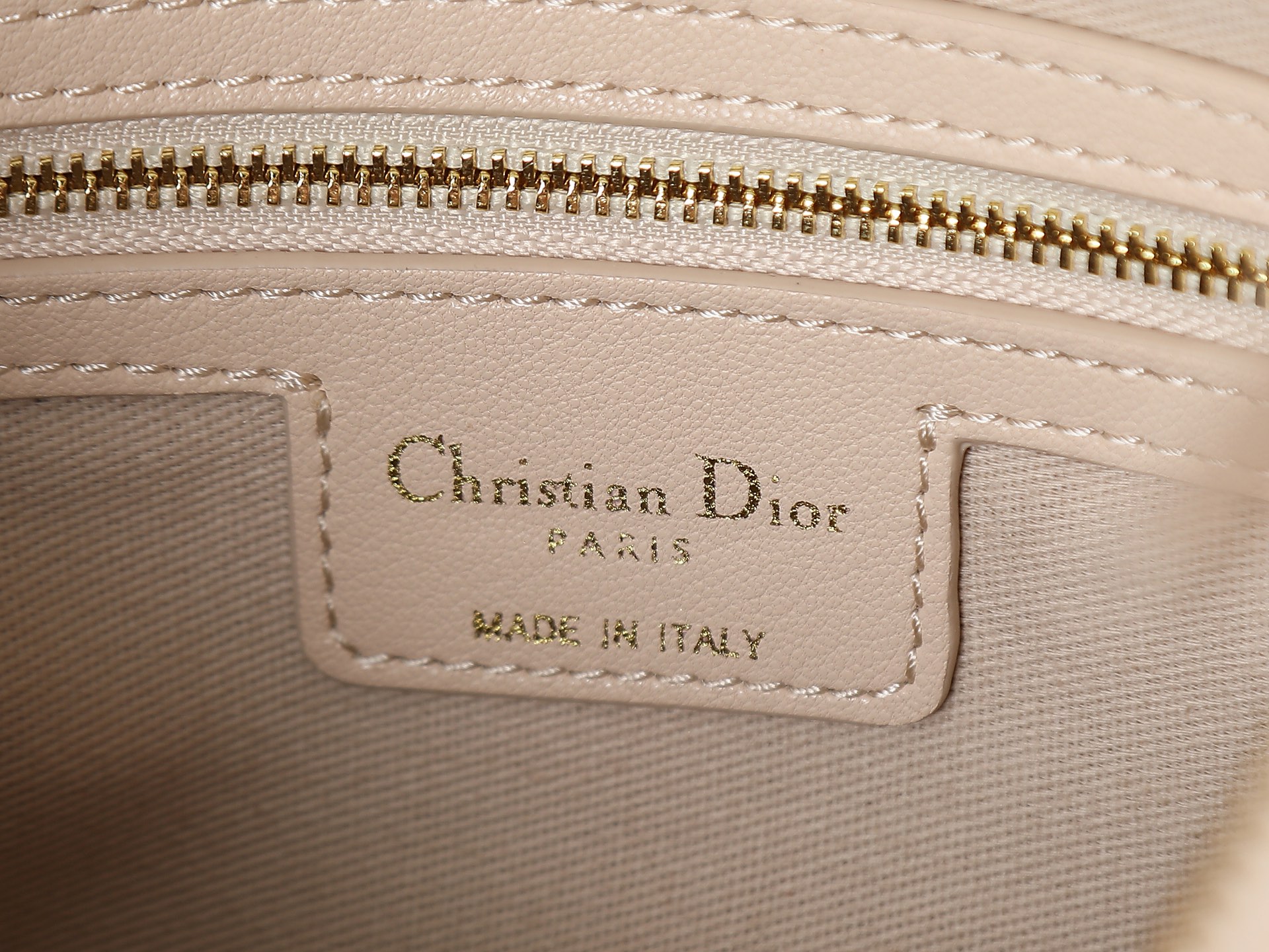 款号2846中号胭脂米色Dior Voyage手袋采用米色褶皱牛皮精心制作，饰有扁平超大藤格纹缉面线，主