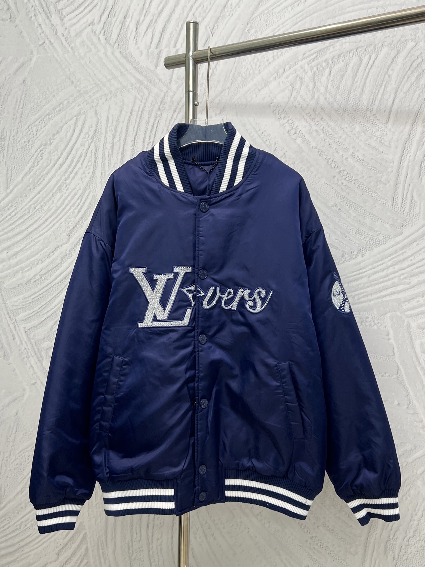 P225 Chaqueta béisbol de algodón y nailon bordado Louis Vuitton. El tejido técnico brillante está adornado con un parch…