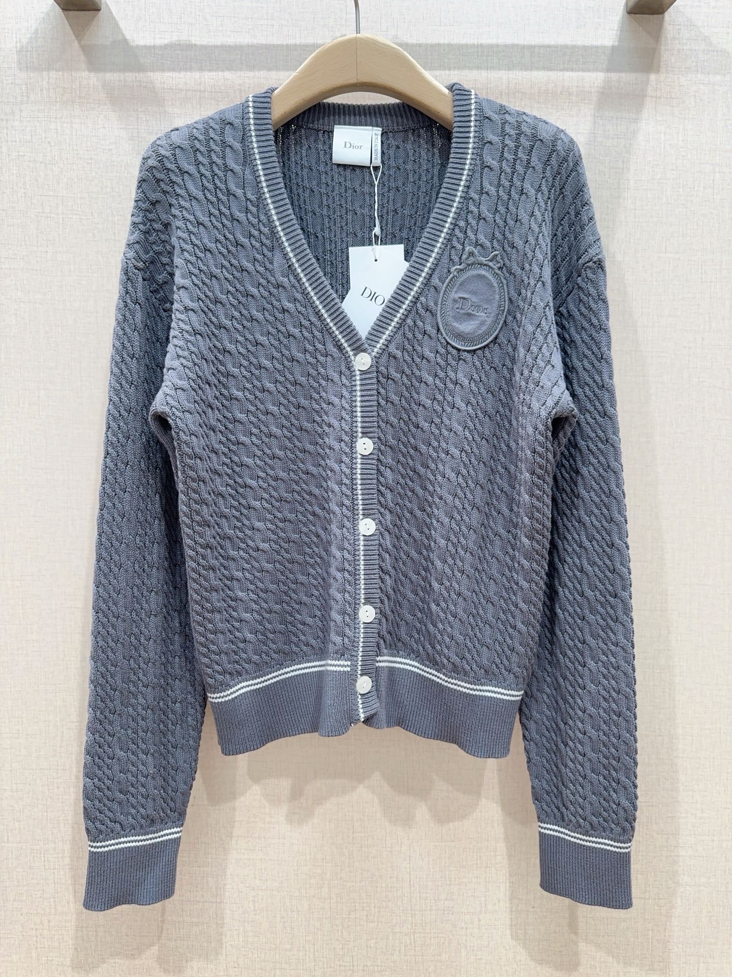 D家灰色麻花针织开衫，新品[爱心][爱心]…… V领设计，白色撞色包边勾勒领口、下摆和袖口，白色纽扣，全身立体绞花肌理，