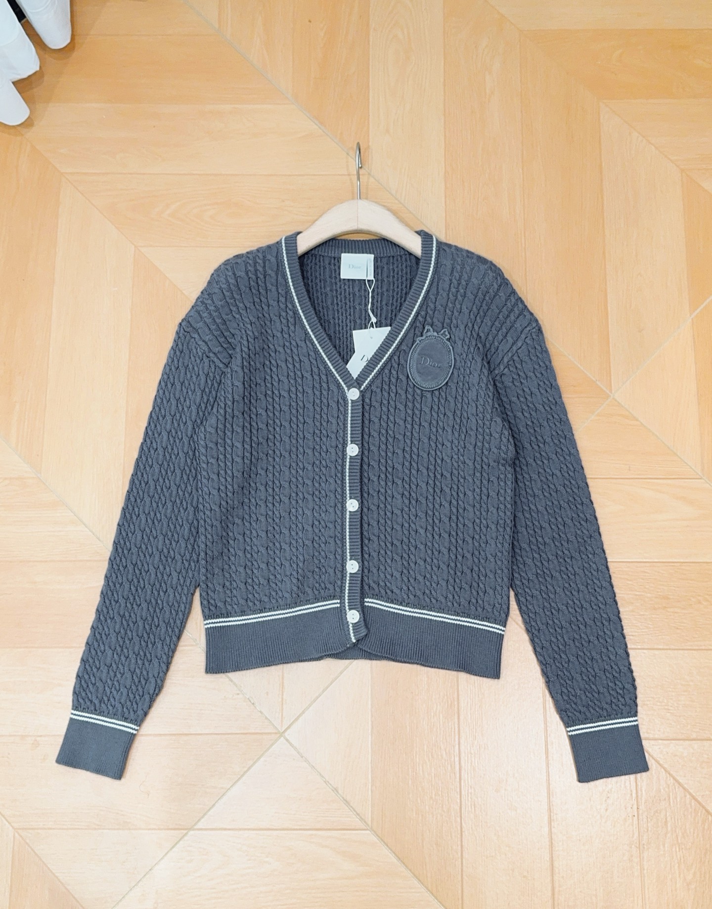 D家灰色麻花针织开衫，新品[爱心][爱心]…… V领设计，白色撞色包边勾勒领口、下摆和袖口，白色纽扣，全身立体绞花肌理，
