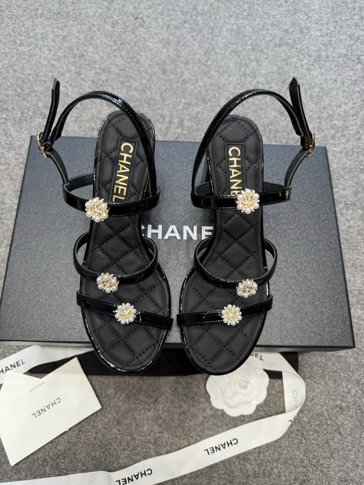 NO:409000,Sandals, Sandals, Chane Xiaoxiang's catwalk pearl buckle thick heel sandals, Chanel high heel sandals, with classic diamond pattern as the bottom, embellished with pearl flowers, suitable for a variety of styles. Paired with the same brand of tweed jacket and chain bag, from daily street out to exquisite dinner, one-click to grasp the high-end atmosphere, every step is to get the elegance of Chanel style. Upper imported beef patent leather inner sheepskin insole sheepskin sole Italian leather outsole height 7.5CM Size35-41 (40 41 custom made without return), boot sandals, chanel, chanel, sandals, boots, jackets & coats, sheepskin, Leather soles19860909凉鞋 凉靴 Chane年小香走秀款珍珠扣粗跟凉鞋 香奈儿高跟凉鞋,以经典菱格纹为底,缀珍珠花朵,适配多种风格.搭配同品牌软呢外套与链条包,从日常出街到精致晚宴,一键拿捏高级氛围感,每一步都走出香奈儿式的优雅 鞋面进口牛漆皮 内里羊皮 鞋垫羊皮 鞋底意大利真皮大底 高度7.5CM Size35-41（40 41订做不退换）,靴子凉鞋,chanel,chanel,sandals,boots,jackets & coats,sheepskin,Leather soles,Women's Shoes