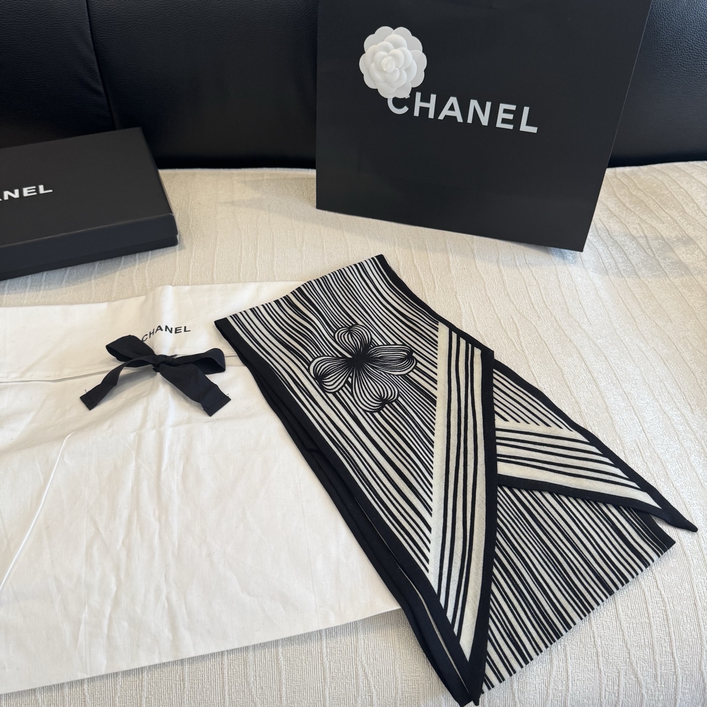这条是Chanel 2026春夏的黑白线条丝巾，手绘流线纹路搭配山茶花和双C元素，流动性很强，视觉上既利落又柔美。