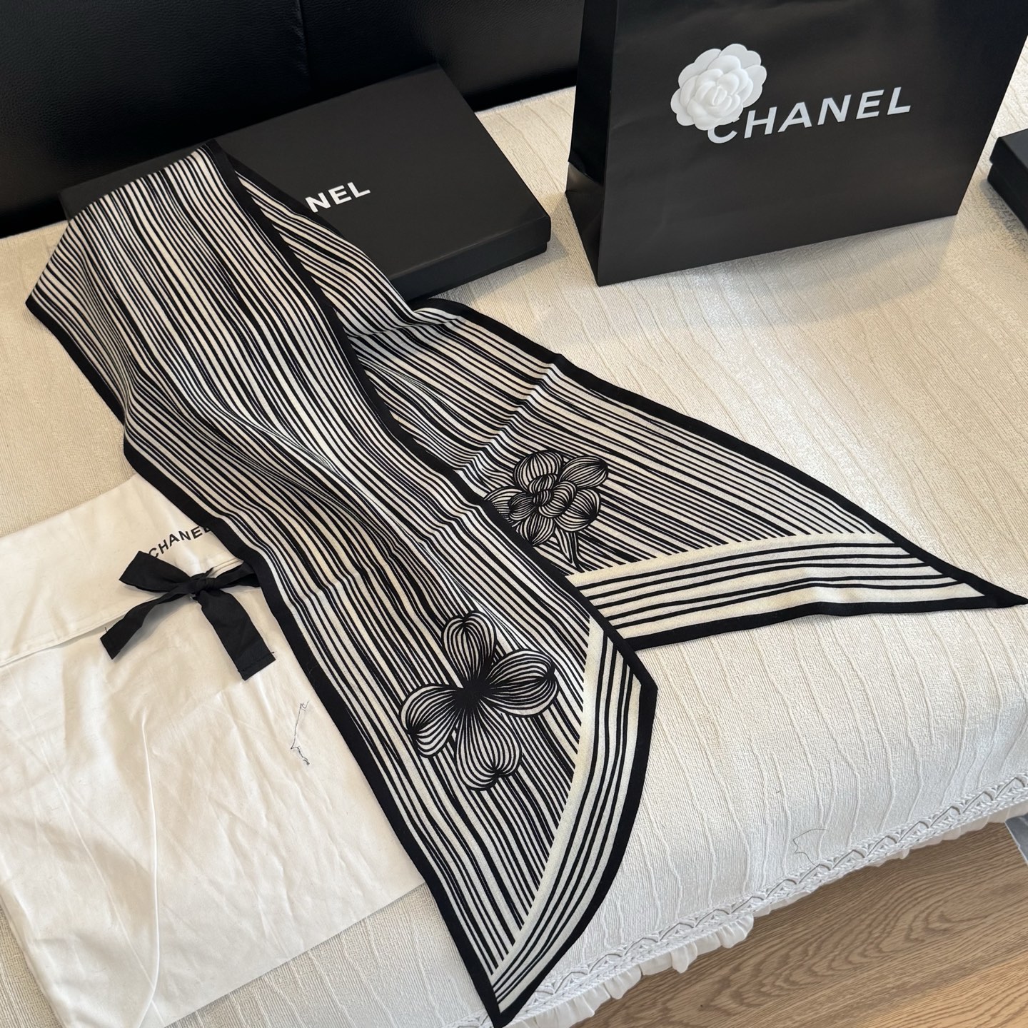 这条是Chanel 2026春夏的黑白线条丝巾，手绘流线纹路搭配山茶花和双C元素，流动性很强，视觉上既利落又柔美。