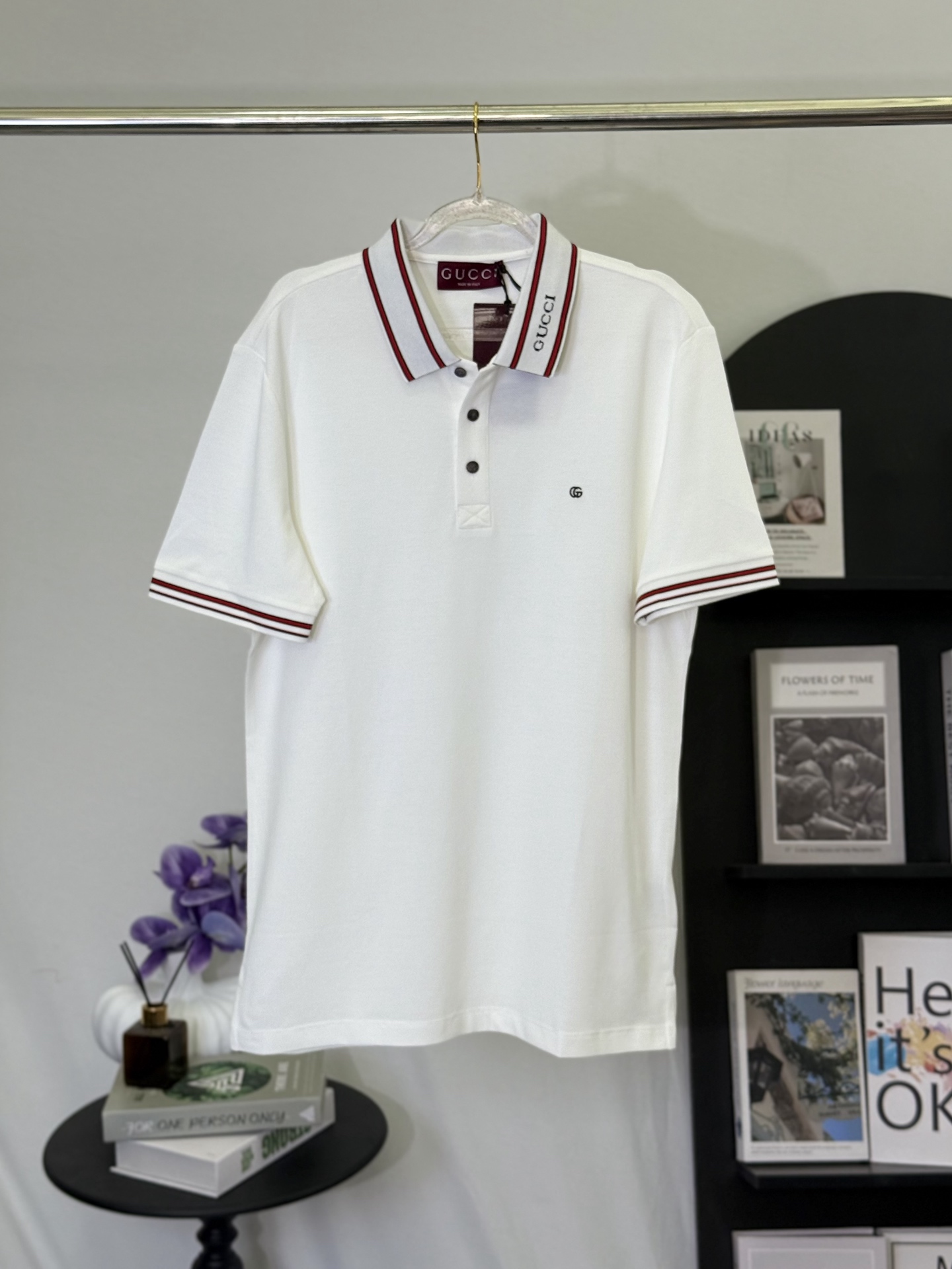 P150 Gucci polo con logo GG bordado de tejido fino sobre fondo blanco. Lleva la elegancia del estilo retro italiano en …