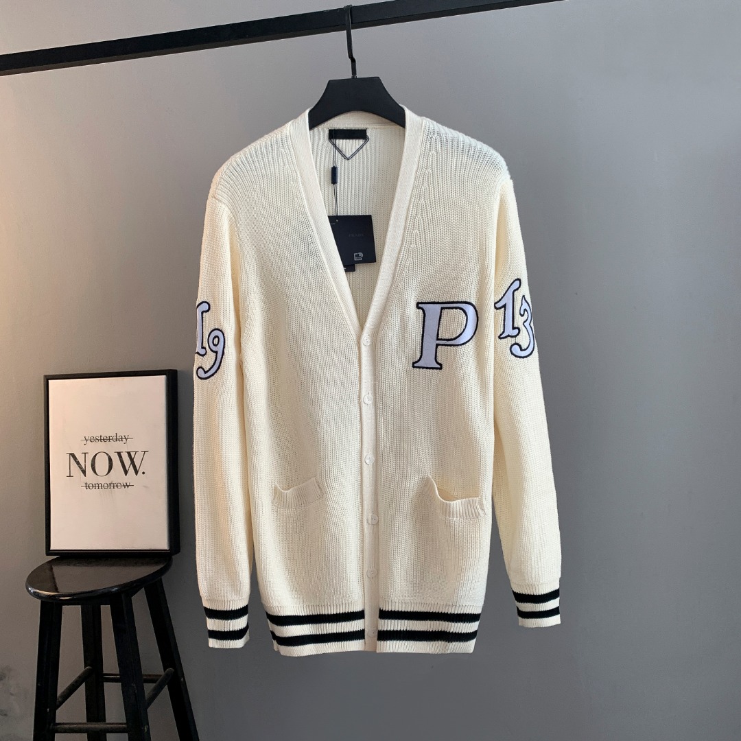 NO:690593,PRADA [PRADA] Prada 25ss New Year's model 1913 embroidered cardigan is made of woolen bulked cotton yarn. Compared with ordinary cotton, bulked cotton has a fluffy and soft feel. The pattern patch of 1319 and P is custom-made by a professional imported Tajima embroidery machine. The pattern has been modified many times by the pattern maker and then stitched twice by a professional marking machine. This style is made of 70.0 sheep wool and 30.0 cashmere. The whole piece has a long-sleeved design.  Rib knitting is used to decorate the edges of the collar. It is paired with a dropped shoulder design. Rib knitting cuffs and hem. The back triangle attachment is made of high-proportion wool yarn. The flat knitting machine uses a coarse needle machine that is different from the large body for knitting. A professional flat machine is used for sewing. The upper body of the clothes is upright. It is skin-friendly and does not tie the body. The buttons are pressed with natural horn, prada, prada,19860909PRADA普拉达【PRADA】普拉达25ss新年款1913刺绣开衫 采用粗纺膨体棉纱 与普通棉相比膨体棉会有种蓬松柔软的手感 版型蓬松 1319和P的图案贴布经过专业进口田岛刺绣机器进行订做而成 图案由制版师修改多次 再由专业打标机两次缝合 此款采用70.0绵羊毛 30.0山羊绒 整件做长袖设计 罗纹针织做衣领边边修饰 搭配落肩款设计 罗纹针织袖口与底边 后面三角附件采用高比例羊毛纱线 横机采用与大身不同的粗针机器进行针织 专业平车进行缝合 衣服上身立挺 亲肤不扎身 扣子采用天然牛角压制而成,,prada,prada,,Men's clothing