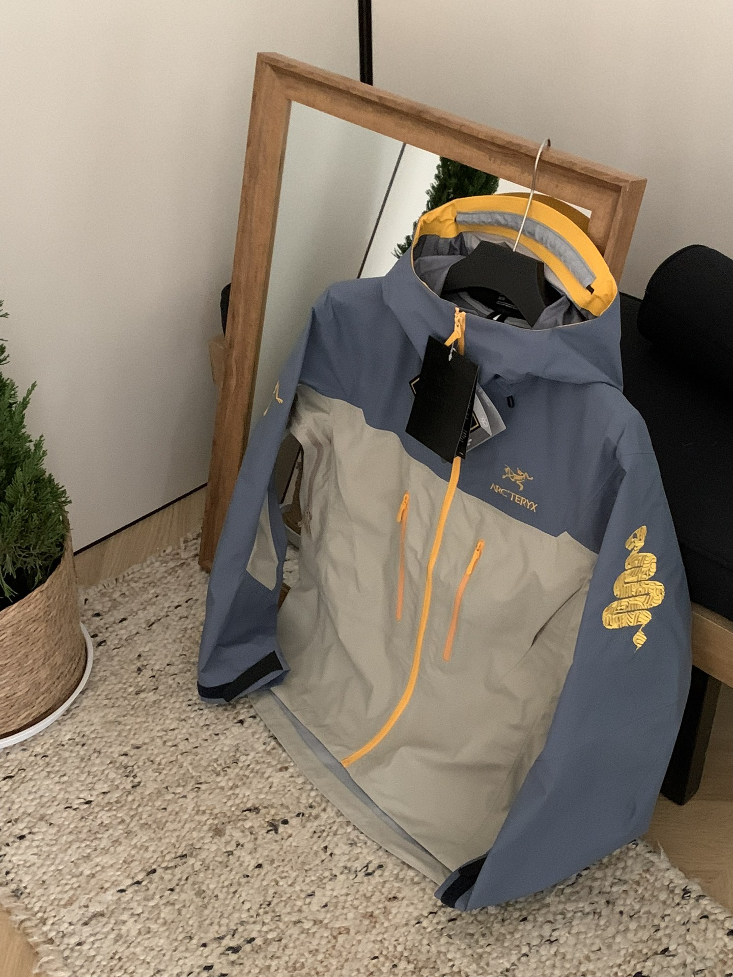 NO:121723,Arcteryx Alpha sv LNY Snake Year Limited. Every Sunday, Archaeopteryx will use the twelve zodiac signs as the idea of ​​a joint new year limited edition. This year is no exception. The logo of the Year of the Snake is the gold-labeled snake pattern on the sleeves is also eye-catching. The hat is also snake scales. The color of the whole dress is golden-dark blue-brown. The overall design looks very bright and the color combination is also very good!  - Alpha SV JACKET Hard Shell Limited Alpha SV JACKET is decorated with snake-shaped patterns on the cuffs and inner pockets, - The edges of the limited hat are also dotted with snake scale printing design. The tough spirit represented by snake 