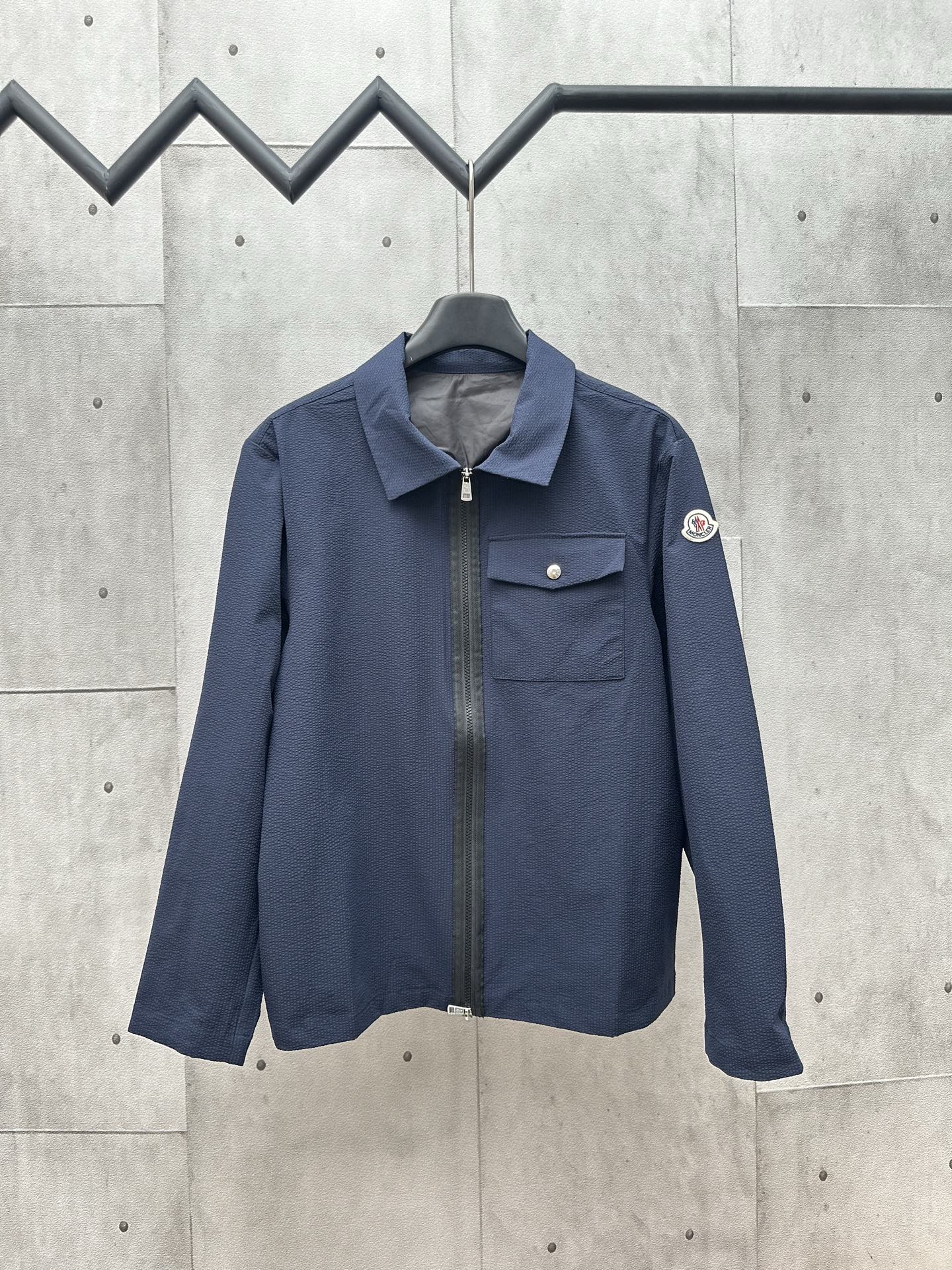 MONCLER泡泡皱衬衫式夹克 面料选择： 选用76%的高棉含量＋24%聚酯纤维的棉质混纺梭织面料。高棉含量确保了面料柔软、亲肤、透气性较好等优点，少量聚酯纤维的加入平衡了整体面料的抗皱性和弹性，大大降低其缩水性。通过预缩处理后，洗涤中尺…