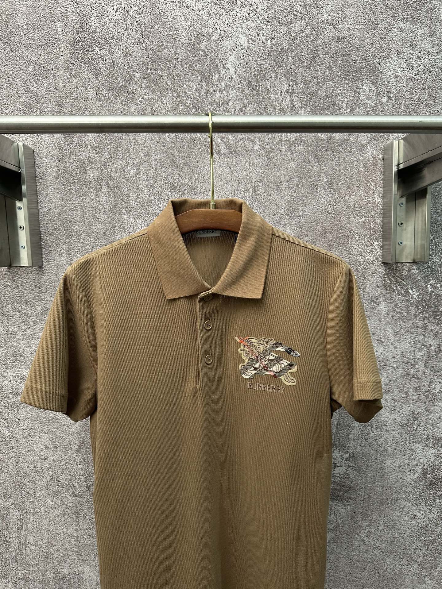 💰p155
Bur*erry  2026 SS 春夏新款
翻领polo短袖衫
珠地棉透气面料
前胸vintage格纹贴布
点缀经典品牌战马刺绣
简约设计风格 不挑人穿
直筒版型
尺码：S M L XL XXL
