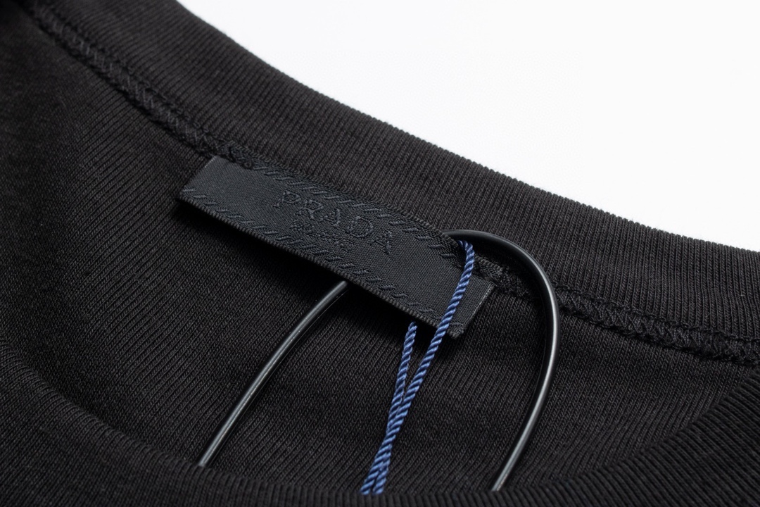  。Prada五金标短袖
面料采用：32支精梳棉 后期面料做了工艺 采用酵母洗水加手感 固定了衣服的版型