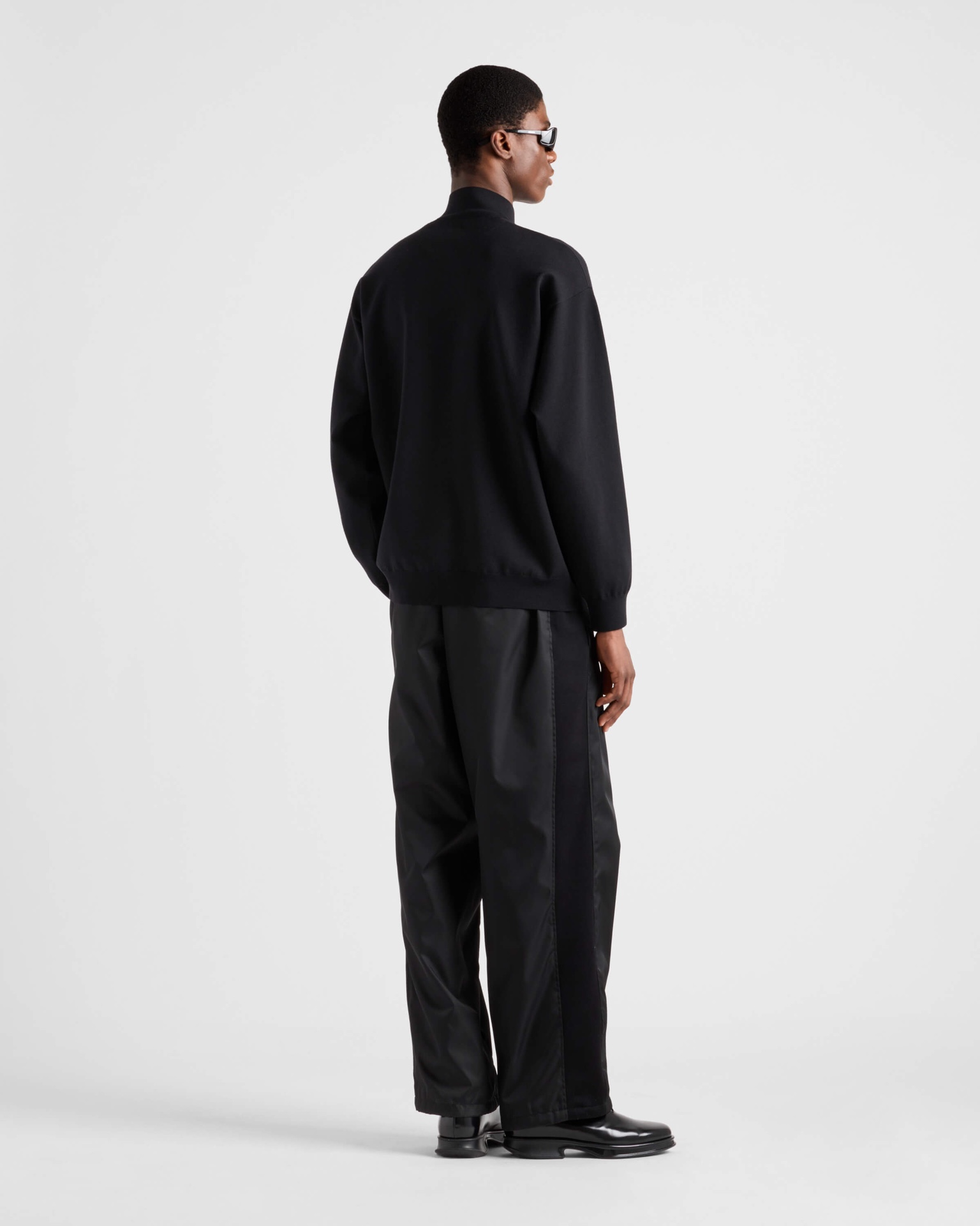 NO:570072,.PRADA Shearling Label Zipper Cardigan is made of merino wool fabric. The wool content is 80.20 cotton. This model is woven with high content of wool content. The weaving method is woven with 12 needles imported from Germany. The high-density weaving method and high wool content can effectively keep warm. It can be used as a base or as an outer layer. The back is made of 50-count double-sided nylon spliced turtle back. The nylon fabric has good fit and comfort to the skin.  Accessory material 1. The zipper uses the original 5 rear pullers. The pull technology is laser engraving and white plating. The pull teeth use European rail teeth, which are very smooth and not easy to get stuck. The overall effect is very high-end. Accessory material 2. The leather label is made of double-layer composite first-layer cowhide, and the brand's iconic LOGO is laser-plated on the face. This wool cardigan has an outstanding and versatile sports style design and is decorated with the iconic triangle logo.   ●Jersey knit ●Oversize version ●Ribbed knit stand-up collar ·Drop shoulders ·Ribbed knitted cuffs and hem ·Front zipper closure ●Enameled triangular metal logo Accessories customized with 11 wash marks Accessories customized with 11 leather labels Accessories customized with 11 zippers Size 46-48-50-52 Color black,,prada,versace,cowhide,alexander wang19860909.PRADA 羊毛皮标拉链开衫 面料面料采用美丽奴羊毛面料,羊毛成份为80,20棉,该款采用高含量羊毛成份织成,织法采用德国进口12针数织出,高密度织法搭配高羊毛成份可有效保暖,可打底可外搭.后背采用50支双面尼龙拼接龟背,尼龙面料对皮肤贴合度与舒适度都非常好. 辅料1拉链采用原版5后拉头,拉头工艺分别为激光刻字与电镀挂白.拉牙采用欧款轨道牙,该款拉牙非常顺滑,不容易卡牙,整体效果非常高端. 辅料2皮标采用头层牛皮双层复合,面部激光电镀出品牌标志性LOGO. 这款羊毛开衫采用出众的百搭运动风设计,饰有标志性三角形徽标. ●平纹针织●Oversize版型●罗纹针织立领 ·落肩·罗纹针织袖口与底边 ·正面拉链开合 ●涂珐琅三角形金属徽标 辅料定制11洗水商标 辅料定制11皮标 辅料定制11拉链 尺码46-48-50-52 颜色黑,,prada,versace,cowhide,alexander wang,Men's clothing