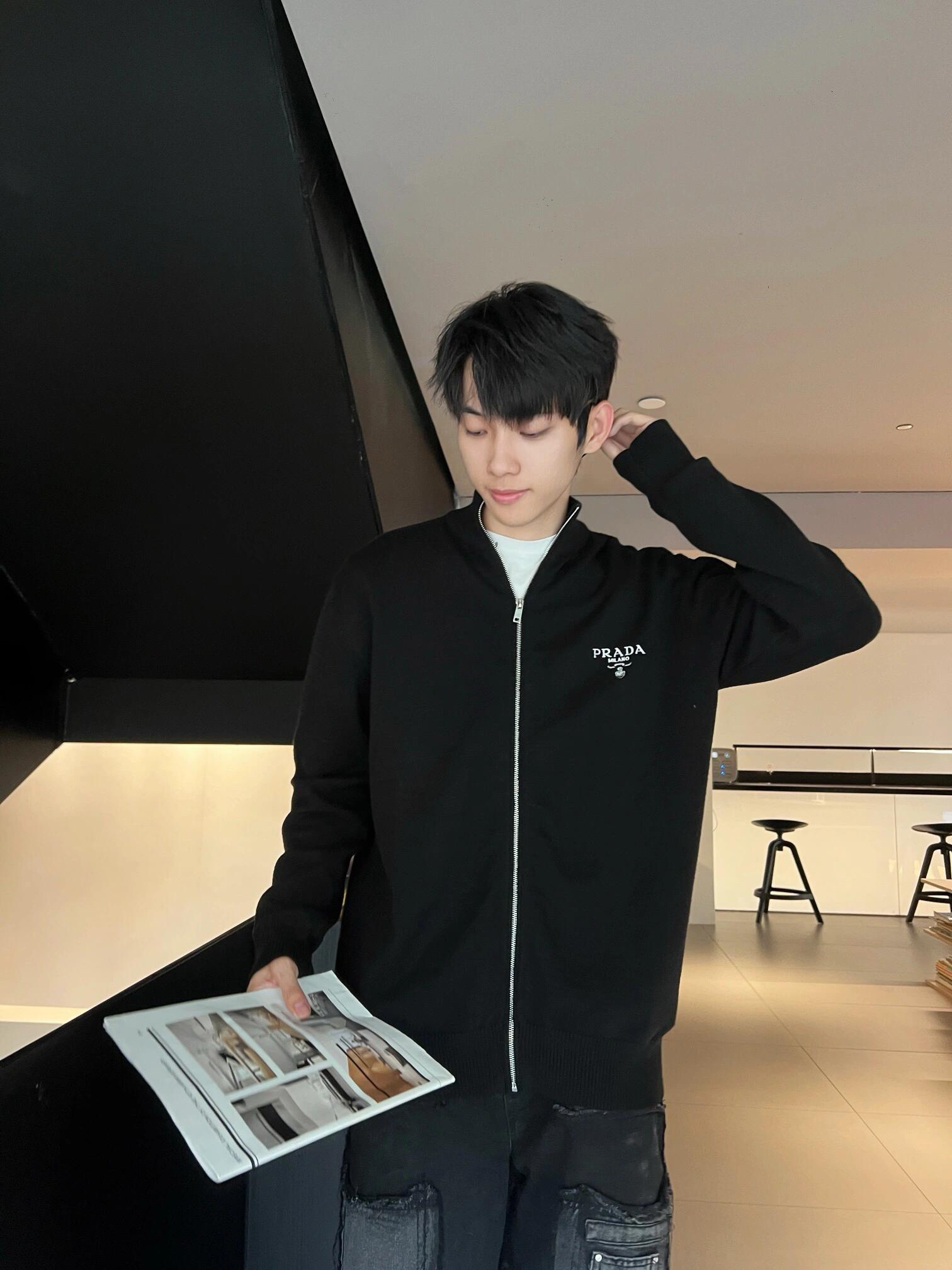 NO:570109,.PRADA wool embroidered zipper cardigan is made of merino wool fabric, and the wool content is 80.20 cotton. This model is woven with high content of wool ingredients. The weaving method is 12 needles imported from Germany. The high-density weaving method and high wool content can effectively keep warm. It can be used as a base or as an outer layer. The back is made of 50-count double-sided nylon spliced turtleback. The nylon fabric has a very good fit and comfort to the skin.  Accessory material 1. The zipper uses the original 5 rear pullers. The pull technology is laser engraving and white plating. The pull teeth use European rail teeth, which are very smooth and not easy to get stuck. The overall effect is very high-end. Accessory material 2. The leather label is made of double-layer composite first-layer cowhide, and the brand's iconic LOGO is laser-plated on the face. This wool cardigan has an outstanding and versatile sports style design and is decorated with the iconic triangle logo.   ●Jersey knit ●Oversize version ●Ribbed knit stand collar ·Drop shoulders ·Ribbed knitted cuffs and hem ·Front zipper closure ●Enameled triangle metal logo Accessories customized with 11 wash marks Accessories customized with 11 leather labels Accessories customized with 11 zippers Size 46-48-50-52 Color gray-black,,prada,versace,cowhide,alexander wang19860909.PRADA 羊毛刺绣拉链开衫 面料面料采用美丽奴羊毛面料,羊毛成份为80,20棉,该款采用高含量羊毛成份织成,织法采用德国进口12针数织出,高密度织法搭配高羊毛成份可有效保暖,可打底可外搭.后背采用50支双面尼龙拼接龟背,尼龙面料对皮肤贴合度与舒适度都非常好. 辅料1拉链采用原版5后拉头,拉头工艺分别为激光刻字与电镀挂白.拉牙采用欧款轨道牙,该款拉牙非常顺滑,不容易卡牙,整体效果非常高端. 辅料2皮标采用头层牛皮双层复合,面部激光电镀出品牌标志性LOGO. 这款羊毛开衫采用出众的百搭运动风设计,饰有标志性三角形徽标. ●平纹针织●Oversize版型●罗纹针织立领 ·落肩·罗纹针织袖口与底边 ·正面拉链开合 ●涂珐琅三角形金属徽标 辅料定制11洗水商标 辅料定制11皮标 辅料定制11拉链 尺码46-48-50-52 颜色灰-黑,,prada,versace,cowhide,alexander wang,Men's clothing