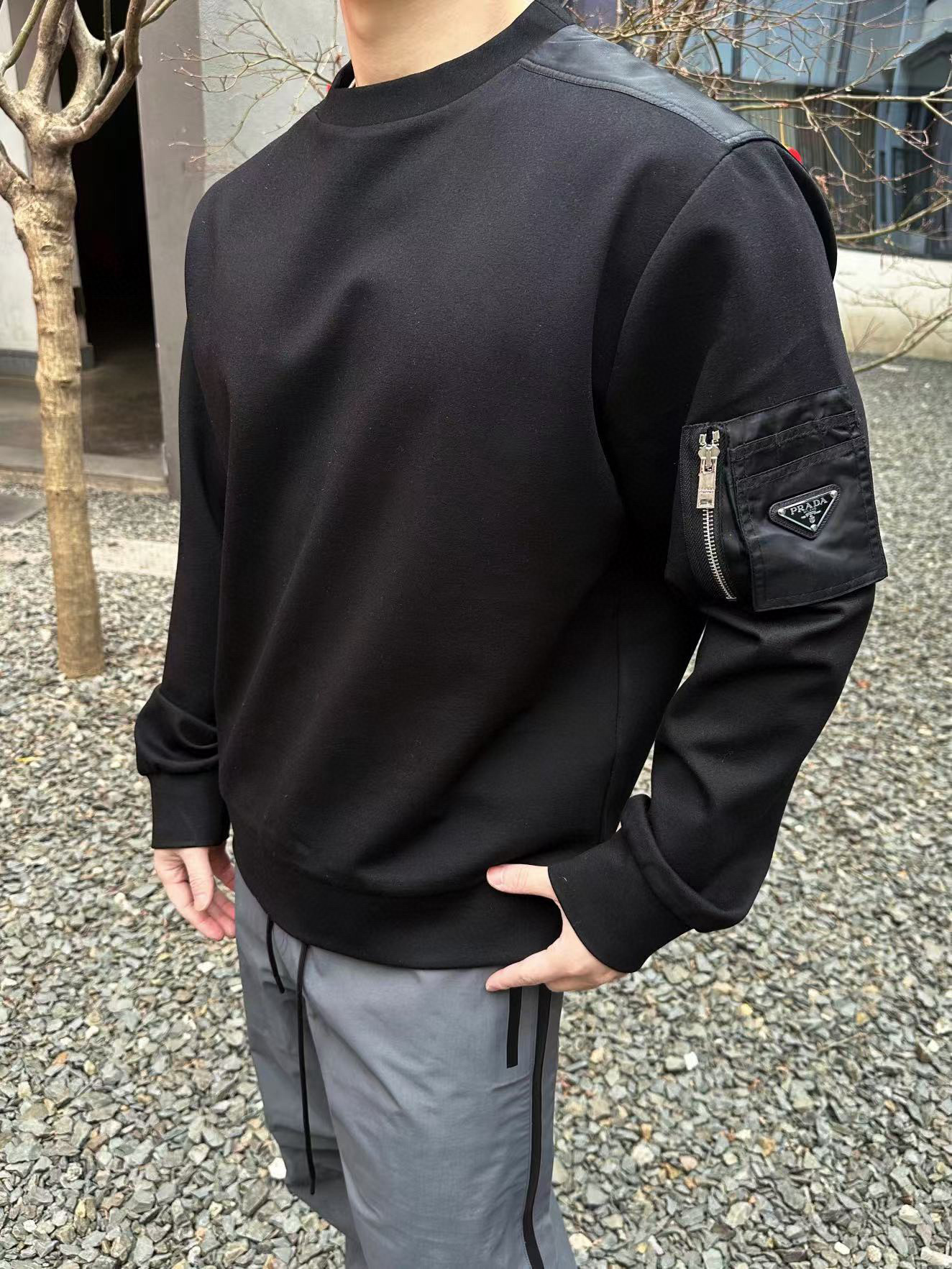 NO:500265,.PRADA Overshoulder Nylon Cuff Pocket Sweater The fabric is 380g double-sided. The fabric is a high-density fixed-woven model, and the upper body is three-dimensional and shaped. The craft laser positioning cut bed is matched with 50 nylon fabric on the back. The cuff positioning cut bed fits the pocket. The auxiliary material 1 zipper uses original No. 5 pull-out, the pull-out is electroplated white laser engraving with brand logo, and the zipper is matched with European pull-out. The auxiliary material 2 leather label uses a soft cowhide double-layer composite with a face, and the white laser engraving brand logo. This cotton sweatshirt is Oversize silhouette, embellished with recycled nylon details, and adds functional elements such as zipper pockets with triangular logos. Oversize shape Long sleeve round neck, straight bottom edge, cotton cuffs, coated enameled triangle metal logo, and zipper pockets with zippered pockets  Customized auxiliary materials 11 washing water trademark Auxiliary materials 11 electroplated zipper Auxiliary materials Customized auxiliary materials 11 electroplated leather label Size S-M-L-XL Color black, Prada, versace, hoodie, sweatshirts, cowhide, alexander wang19860909.PRADA 过肩尼龙袖口袋卫衣 面料采用380克双面,该款面料为高密度定织款,面料上身立体有版型. 工艺激光定位裁床,后幅过肩设计风格采用50支尼龙面料搭配.袖口位置定位裁床贴合口袋. 辅料1拉链采用原版5号拉头,拉头电镀挂白激光刻字带有品牌logo,拉链搭配欧款拉牙. 辅料2皮标采用头层软牛皮双层复合,面部电镀挂白激光刻字品牌标志性logo. 这款棉质运动衫为Oversize廓形,点缀再生尼龙细节,加入带三角形徽标的拉链口袋等功能性元素. Oversize造型 长袖圆领 平直底边 棉质袖口 涂珐琅三角形金属徽标 衣袖饰有拉链口袋 辅料定制11洗水商标 辅料定制11电镀拉链 辅料定制11电镀皮标 尺码S-M-L-XL 颜色黑,,prada,versace,hoodie,sweatshirts,cowhide,alexander wang,Men's clothing