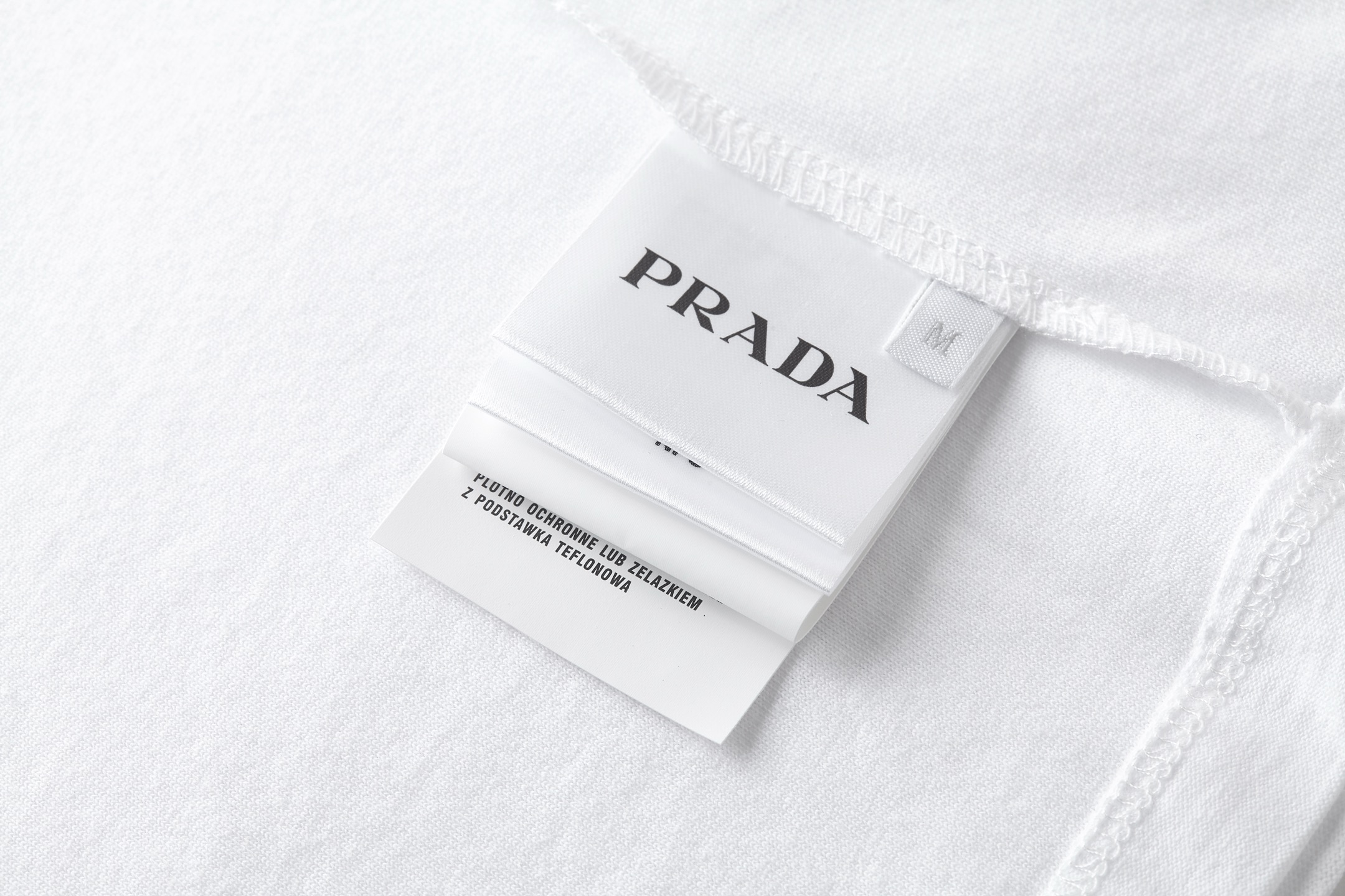。PRADA 毛巾刺绣标识短袖面料：采用16支麻绵单面，原版定染定织。面料：螺纹搭配1*1索罗娜。工艺：