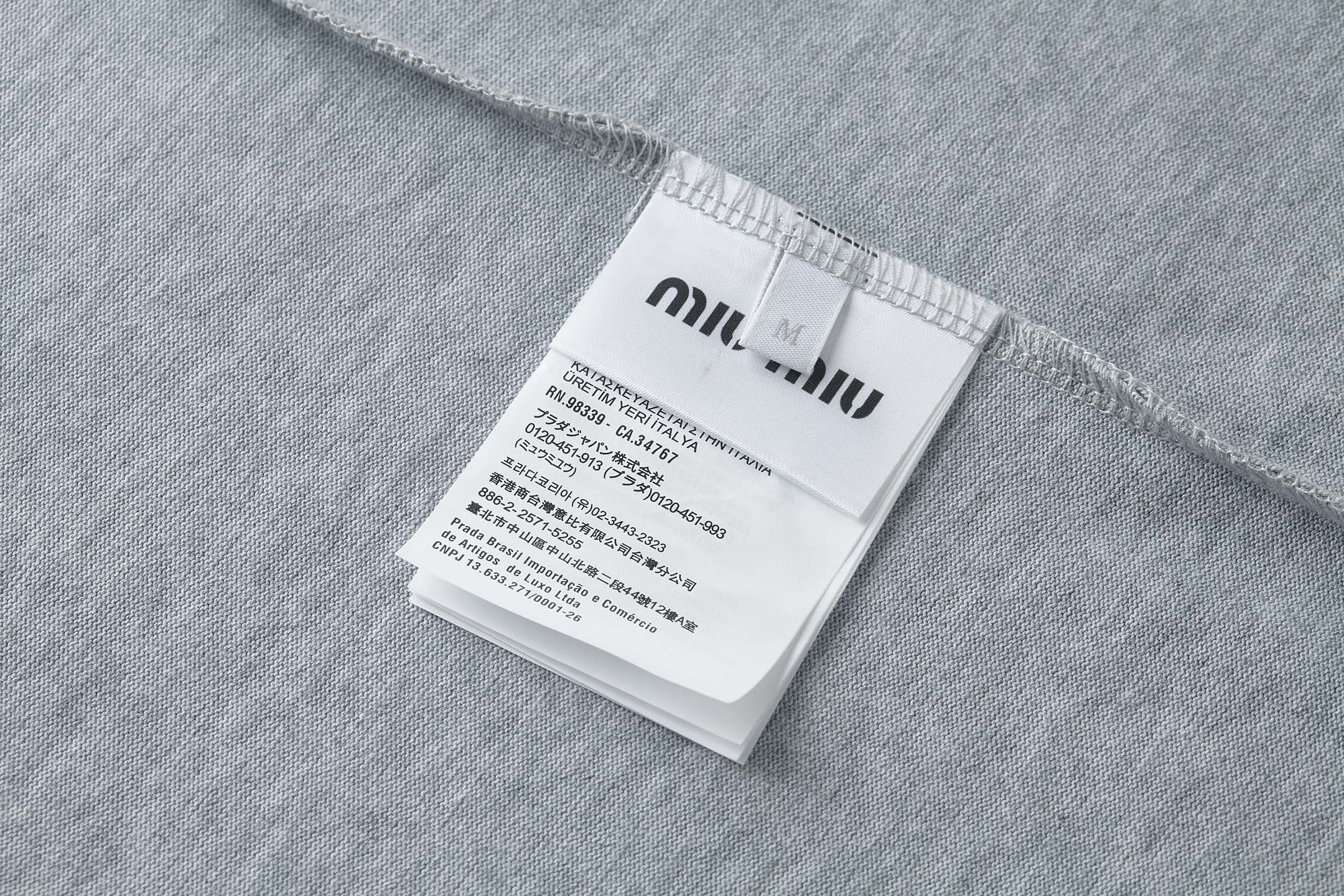 Miu Miu Miu Miu衣橱中的标志性面料搭配呈现紧凑外观，塑造这款工装风格 Polo衫的廓形，功能性与前卫美学完美融合