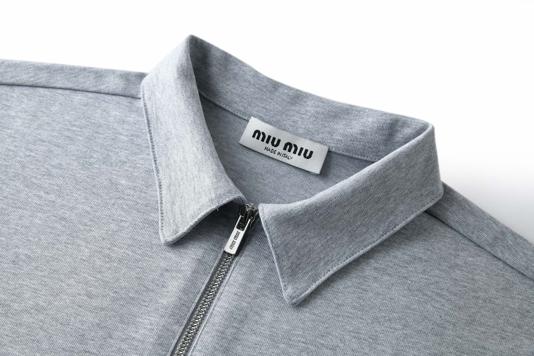 Miu Miu Miu Miu衣橱中的标志性面料搭配呈现紧凑外观，塑造这款工装风格 Polo衫的廓形，功能性与前卫美学完美融合