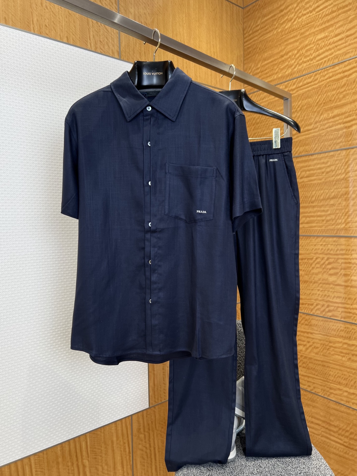 NO:827773,/Set PRA classic logo embroidered drape short-sleeved shirt set ——————  Made of specially imported high-twisted Tencel blended fabric, the texture is drapey and soft with a smooth satin texture. It feels cool to the skin and has excellent breathability and anti-wrinkle properties. It will not wrinkle and deform easily after long-term wear, and can easily create a neat and stress-free texture. The shirt adopts a classic lapel with slightly dropped shoulders and short sleeves. The matching trousers are designed with a high-elastic elastic waistband and are paired with slightly wide straight trousers.  The brand logo is embellished in the same way, and the details echo to make the set more high-end; the whole set adopts a unified texture, showing delicate and soft luster changes under different lights. It is unobtrusive but has a relaxed atmosphere. It can be easily controlled whether it is daily commuting, leisure travel or light business occasions. It is a tool for lazy people to wear that combines comfort, style and practicality, creating effortless high-quality outfits for urban men.  ————————88104088 Material: blended, loose fit, color burgundy/navy blue/white, size S/M/L/XL, Prada-clothing, prada, prada, shirts, T-shirt,19860909/套 PRA经典标识刺绣垂感短袖衬衫套装 —————— 采用进口特供高捻天丝混纺面料,质地垂坠软糯自带柔滑缎面肌理,触感冰爽亲肤兼具出色的透气性与抗皱性,久穿不易起皱变形,轻松打造利落无压质感；衬衫采用经典翻领搭配微落肩短袖剪裁,配套长裤采用高弹松紧腰头设计,搭配微阔直筒裤型,不挑身材包容度拉满,裤腰处同样点缀品牌标识,细节呼应更显成套高级感；整套采用统一的肌理,在不同光线下呈现出细腻柔和的光泽变化,不张扬却自带松弛氛围感,无论是日常通勤、休闲出行还是轻商务场合都能轻松驾驭,是兼顾舒适、格调与实用性的懒人穿搭利器,为都市男士打造不费力的高级质感穿搭. ————————88104088 材质: 混纺 版型宽松 颜色酒红/藏蓝/白色 尺码S/M/L/XL,普拉达-服装,prada,prada,shirts,T-shirt,,Women's clothing