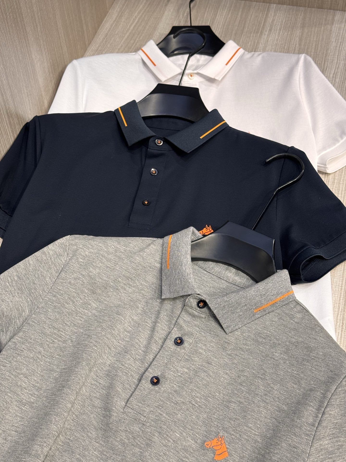 NO:160577,, Model HS051#, Aima Family  The latest 2025 spring and summer horse head embroidered men's lapel T-shirt, light business style Polo shirt, simple and versatile, not picky for people to wear. The representative orange horse head pattern on the chest adopts high-end 3D three-dimensional embroidery process, which is small and exquisite, full and stylish, echoing the orange trim of the collar and the orange stitching of the placket buttons (the unique design of the orange stitching on all buttons just made into a 