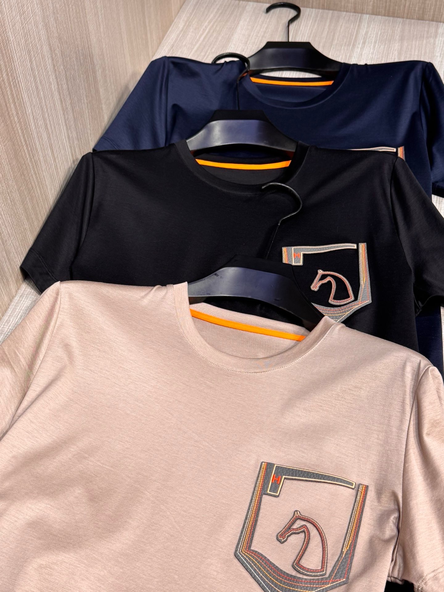 NO:160584,, Model HS023#, Aima Family  The latest horse head leather logo for men's round neck T-shirt in spring and summer 2025, the basic style of the traditional public, not picky for people to wear, the representative horse head pattern on the chest is made of high-end heavy industry laser leather embroidery (made from imported washing lambskin, very soft and delicate, and has been washed, so everyone can flip it and throw it into the washing machine to wash it). It is exquisite and exquisite, with a strong texture and three-dimensional feeling. It is paired with unique color line embroidery, shining and eye-catching, and the iconic orange H embellishment instantly injects soul, improving the grade, and extremely high brand identity; the upper body is stylish and stylish, and it has both connotation and taste. Whether worn alone in summer or with various shirts or jackets in spring and autumn, it is a perfect combination of low-key luxury and trendy fashion. You can create a full-size urban elite male god style!  A slightly loose basic style with small slits on both sides of the hem meet the simple needs of commuters for dressing. The upper body is very effective, it looks slim and youthful, and it is super versatile. A seemingly simple T-shirt can also be worn with good taste. The top-grade fabric Lanjing Tianshi (70 Tianshi, 30 cotton, and professional institutions provide test reports). The touch is super good, and it feels softer and smoother than ordinary mercerized cotton, and it is more refreshing and comfortable to wear. It will not fade and will not deform after wearing for a long time. Size M-XXL (model 172 cm 148 catties and try on L size) 3 colors black, hidden blue, apricot color, hermes, jackets & coats,shirts,tees, t-shirt, sheepskin, alexander wang19860909,型号HS023#,爱马家 2025春夏最新马头贴皮徽标男士圆领T恤衫,传统大众的基础款型,不挑人穿,胸前极具代表性的马头图案,采用高端重工的激光贴皮绣工艺（进口水洗小羊皮制作,很柔软很细腻,而且已经水洗过,大家放心翻转丢洗衣机洗涤即可）,精致考究,质感极强,富有立体感,搭配独特的彩色线条刺绣,闪亮吸睛,再加上标志性的桔色H点缀,瞬间注入了灵魂,提升了档次,品牌标识度极高；上身有型有格调,同时又兼具内涵与品味,无论夏季单穿,还是春秋季搭配各式衬衫或者外套,都是低调奢华与潮流时尚的完美结合,随意穿搭都能打造出逼格满满的都市精英男神范儿！稍带宽松的基础版型,下摆两侧小开衩,满足通勤人们对于着装的简约需求,上身效果很好,显瘦显年轻,又超级百搭,看似简单的T恤也能穿出好品位. 进口客供顶级面料兰精天丝（70天丝,30棉,专业机构提供检测报告）,手感超级赞,摸上去比一般丝光棉更加柔软顺滑,穿着更加冰爽舒适,且久穿久洗不褪色不变形.尺码M-XXL（模特172厘米148斤试穿L码合适）3个颜色黑色,藏蓝,杏色,,hermes,jackets & coats,shirts,tees，t-shirt,sheepskin,alexander wang,Men's clothing