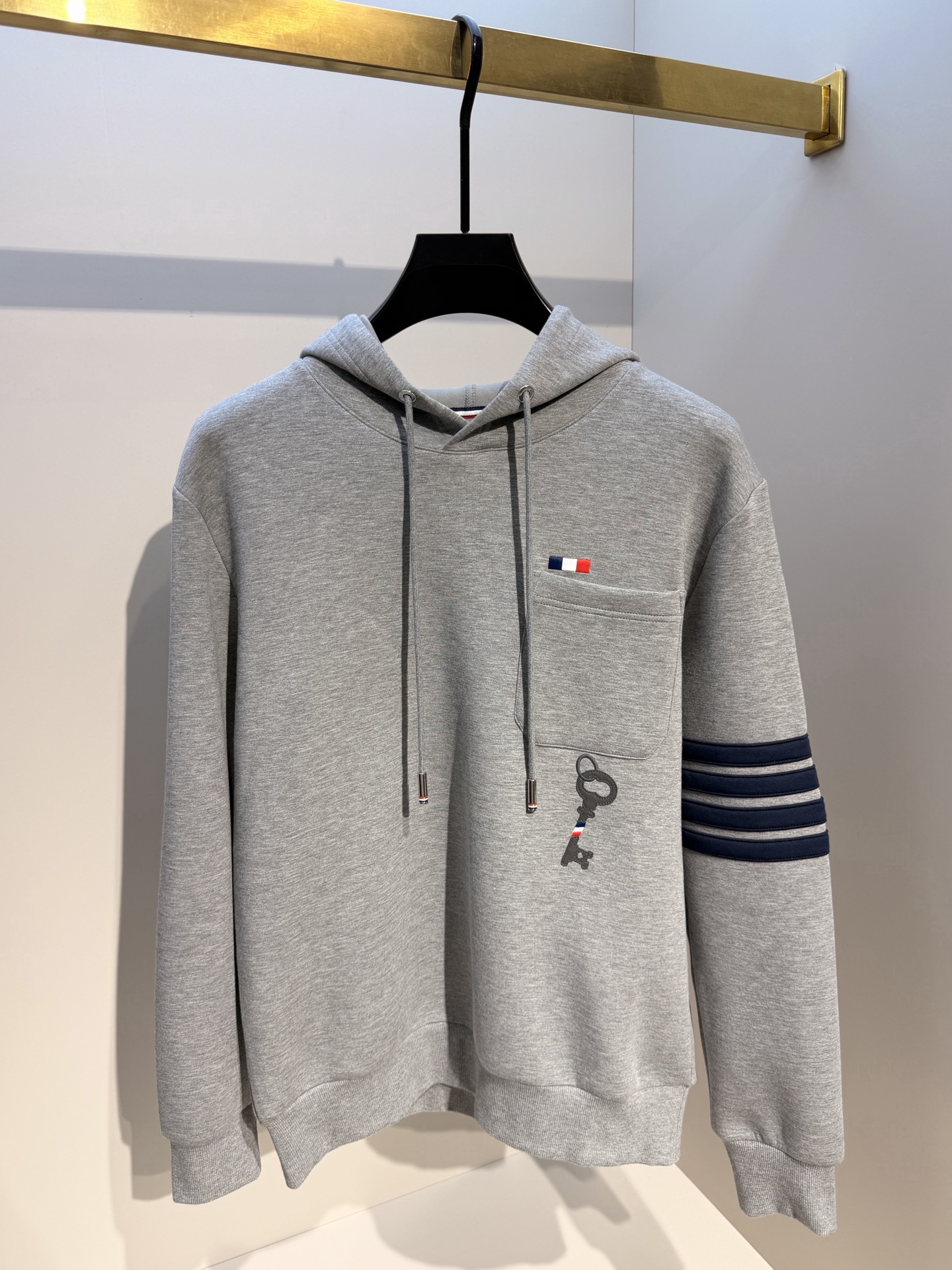 型号L901QD#，TB家 2026秋冬最新钥匙绣标男士连帽运动衫，传统套头带帽卫衣款型，胸前雅致口袋设计，搭配经典红白