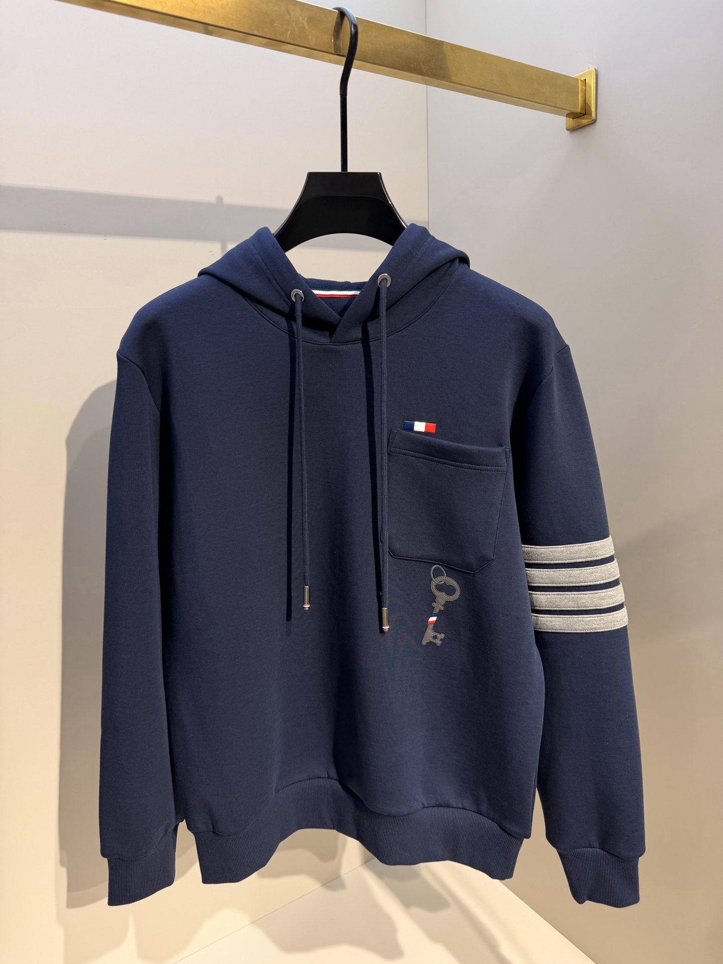 型号L901QD#，TB家 2026秋冬最新钥匙绣标男士连帽运动衫，传统套头带帽卫衣款型，胸前雅致口袋设计，搭配经典红白